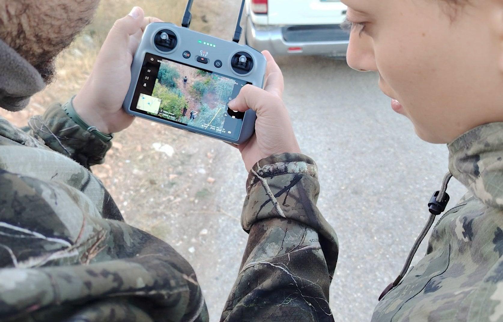 Ein Mann hält den Controller einer Drohne in der Hand, auf dem Display sind Vogelfänger an Netzen zu sehen.