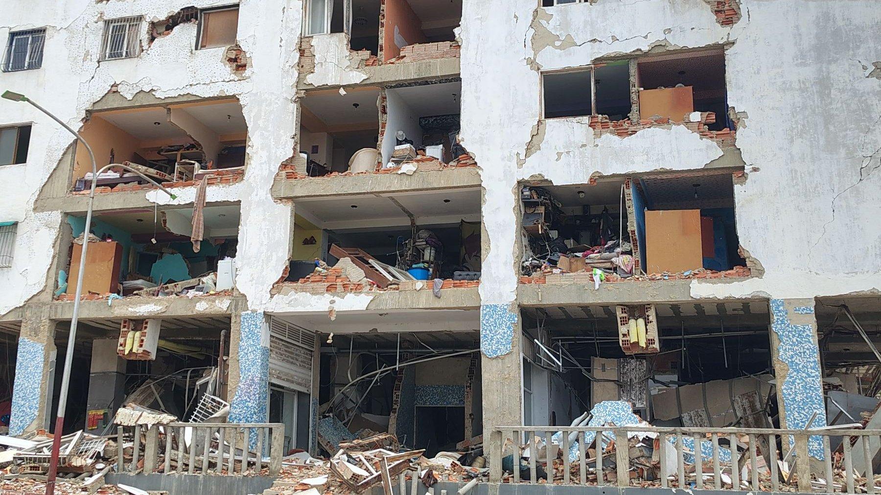Die Vorderfront eines Hochhauses, die Mauern der ersten vier Stockwerke sind stark beschädigt.