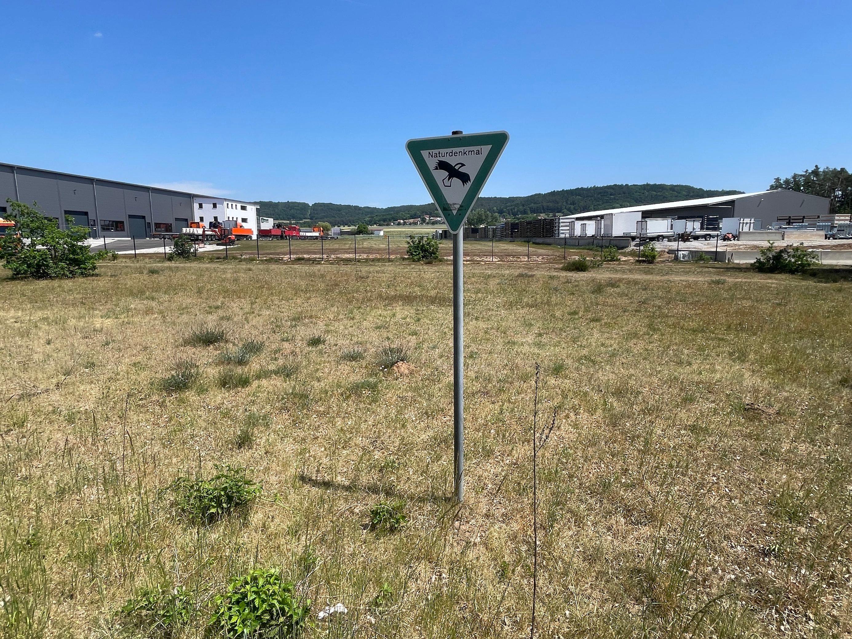Karge Vegetation, Schild Naturdenkmal, Gewerbegebiet.