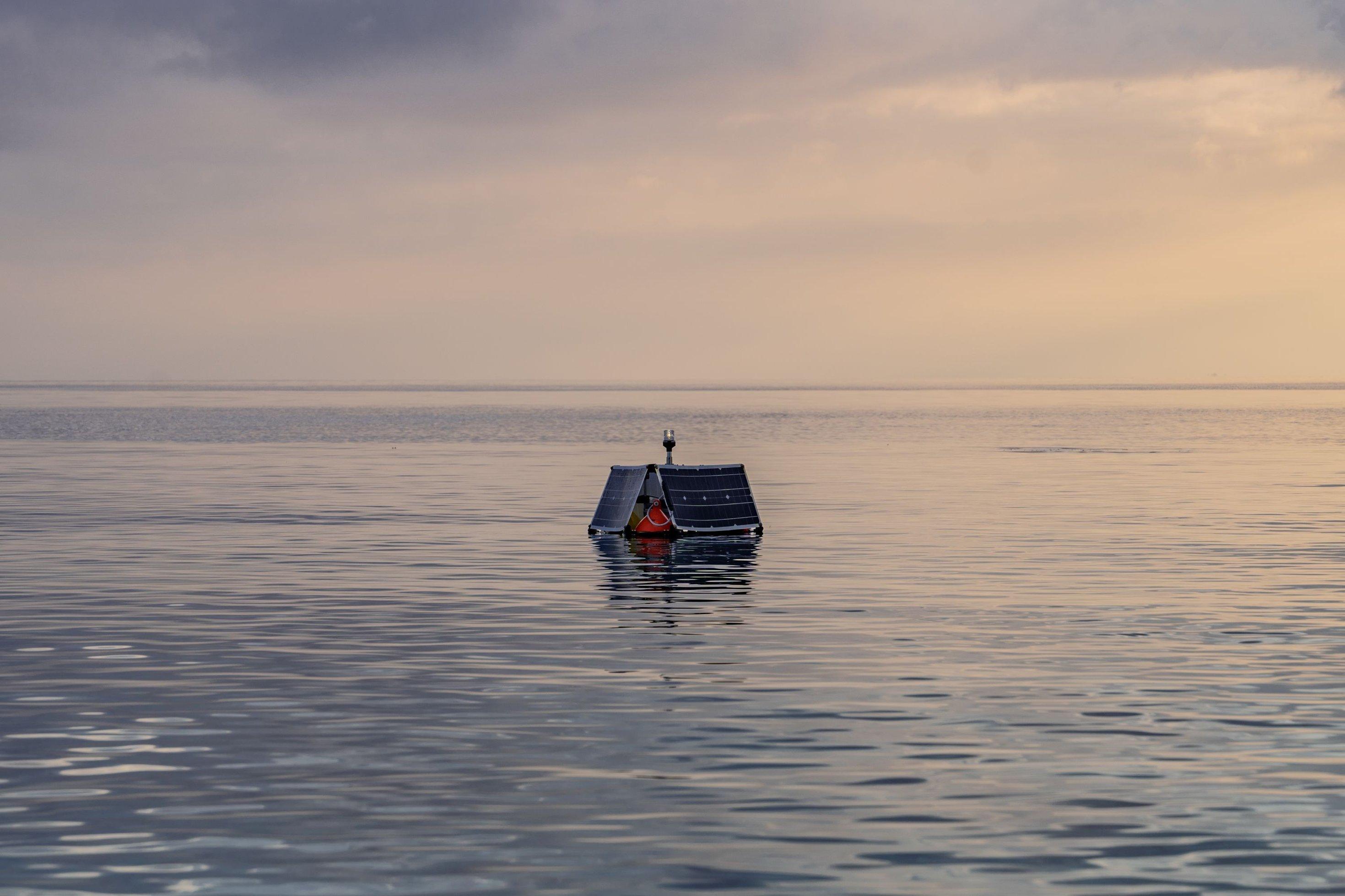 Aneinandergelehnte Solarpanele mit schwimmendem Unterbau auf ruhiger See.