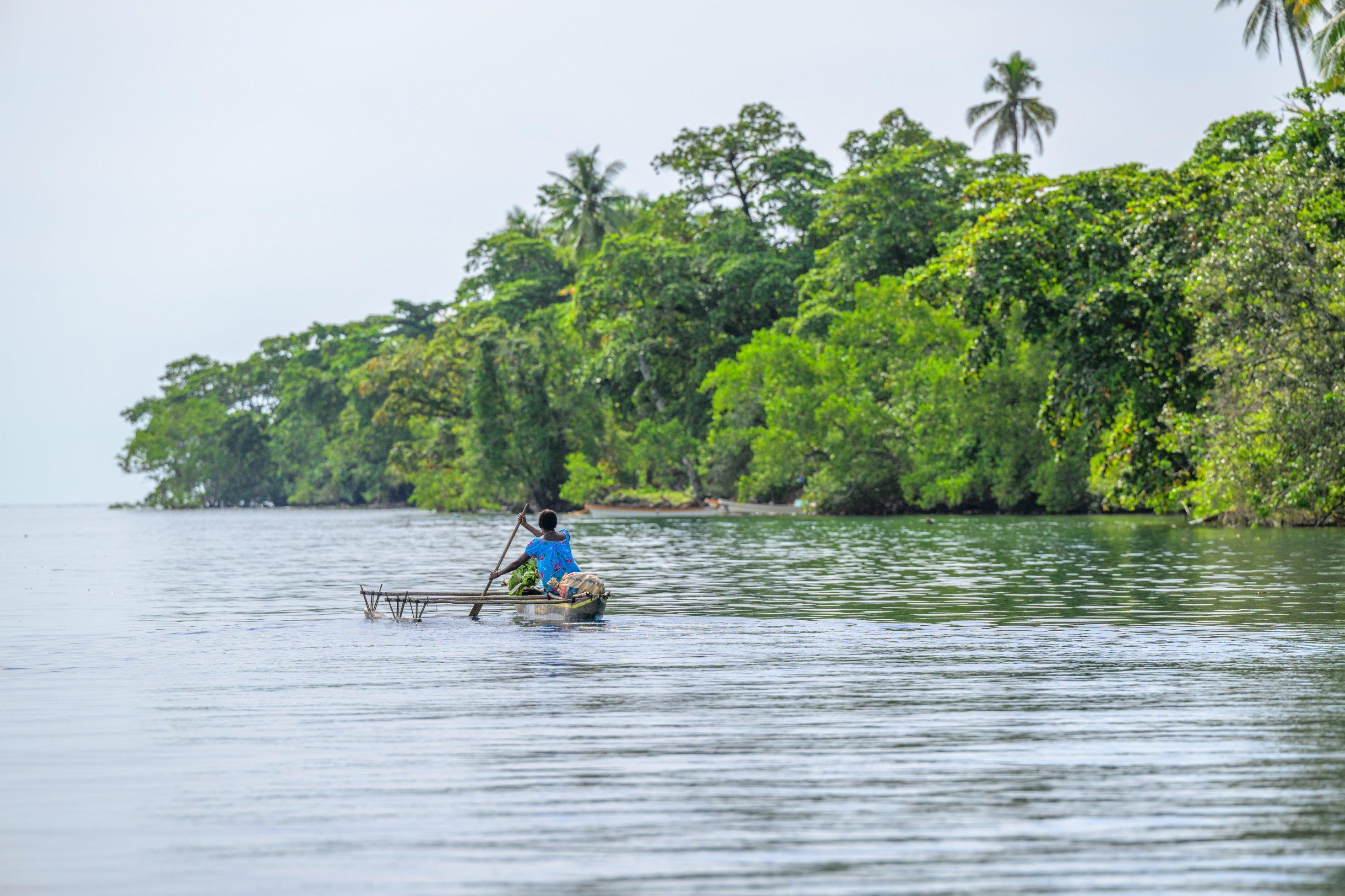A fisherwoman in an outrigger canoe near Palmalmal. Pomio District, East New Brotain Province, New Britain, Papua New Guihnea.
