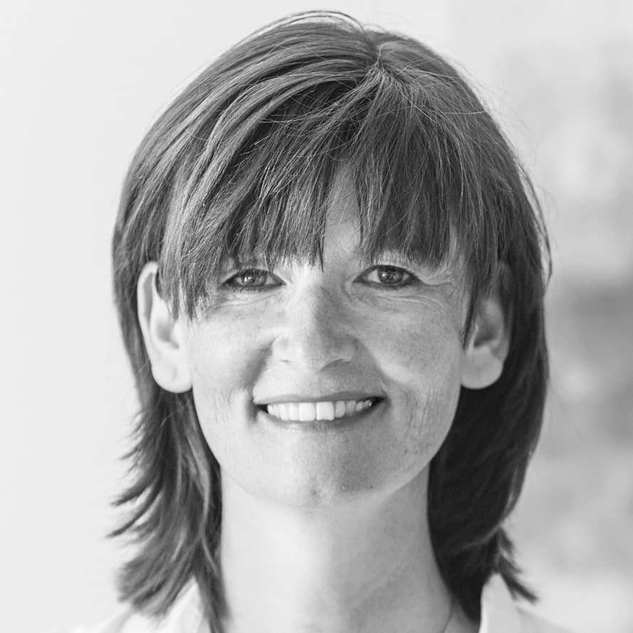 Schwarz-weißes Porträt der lächelnden  Autorin Andrea Reidl.