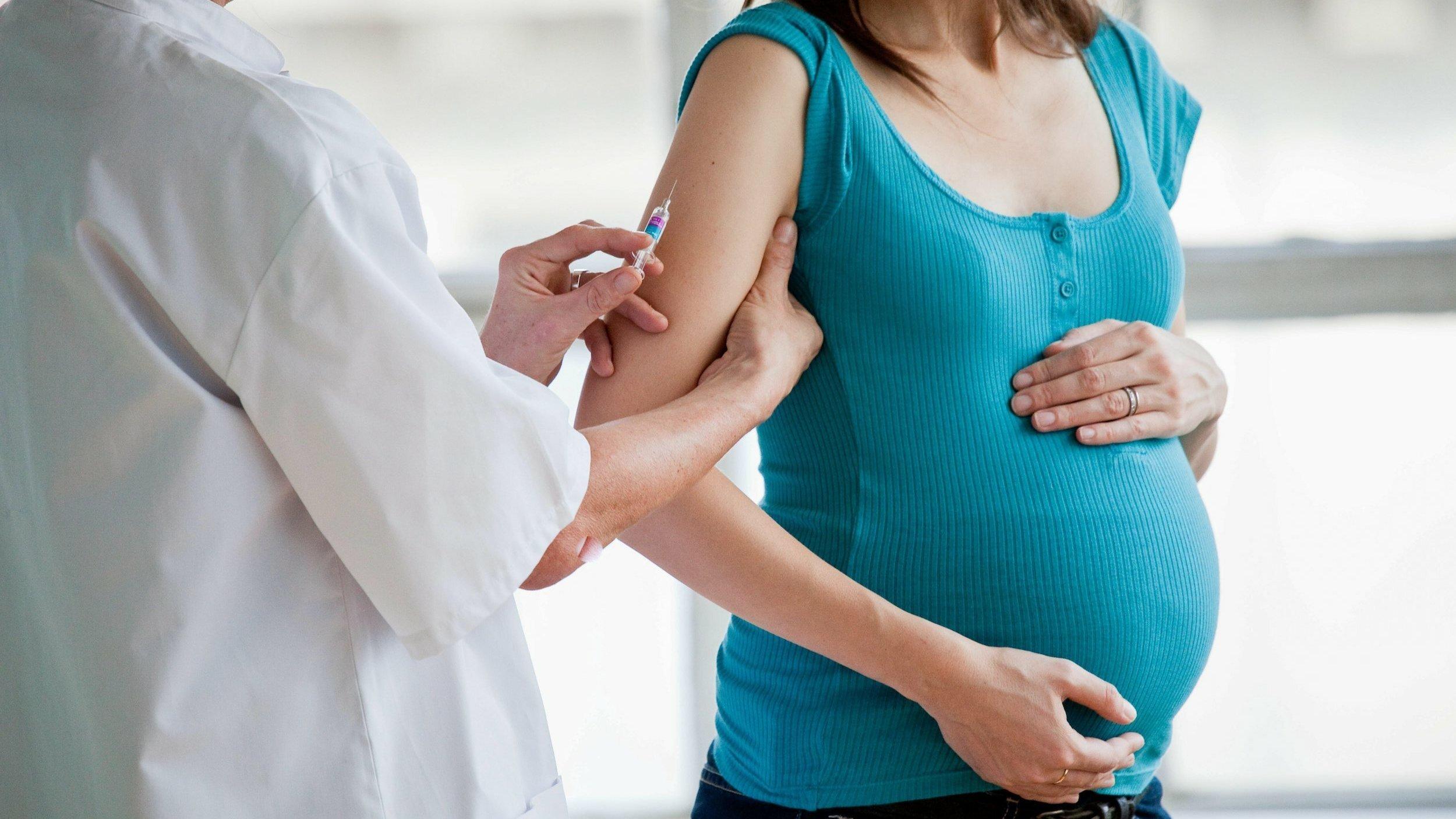 Eine schwangere Frau wird geimpft.