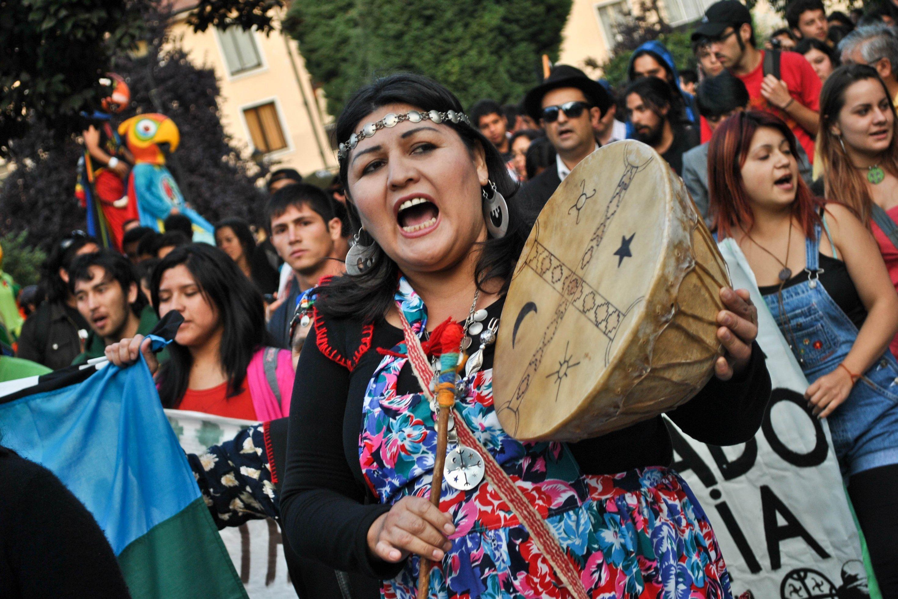 Eine Mapuche-Frau hält eine Trommel