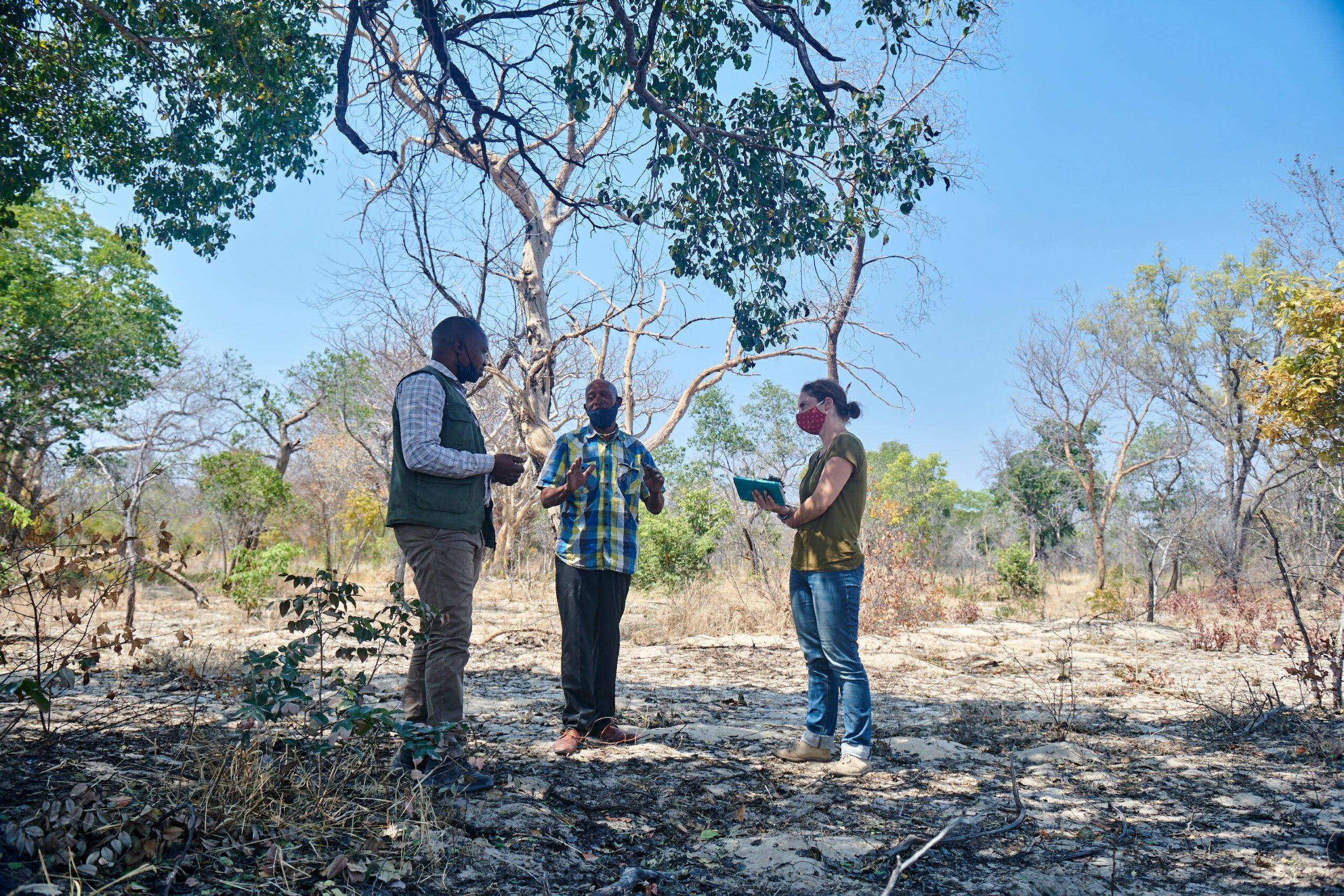 In der Mitte steht Forest San Mahindi, links von ihm San Aktivist Satau und auf der rechten Seite Journalistin Leonie March