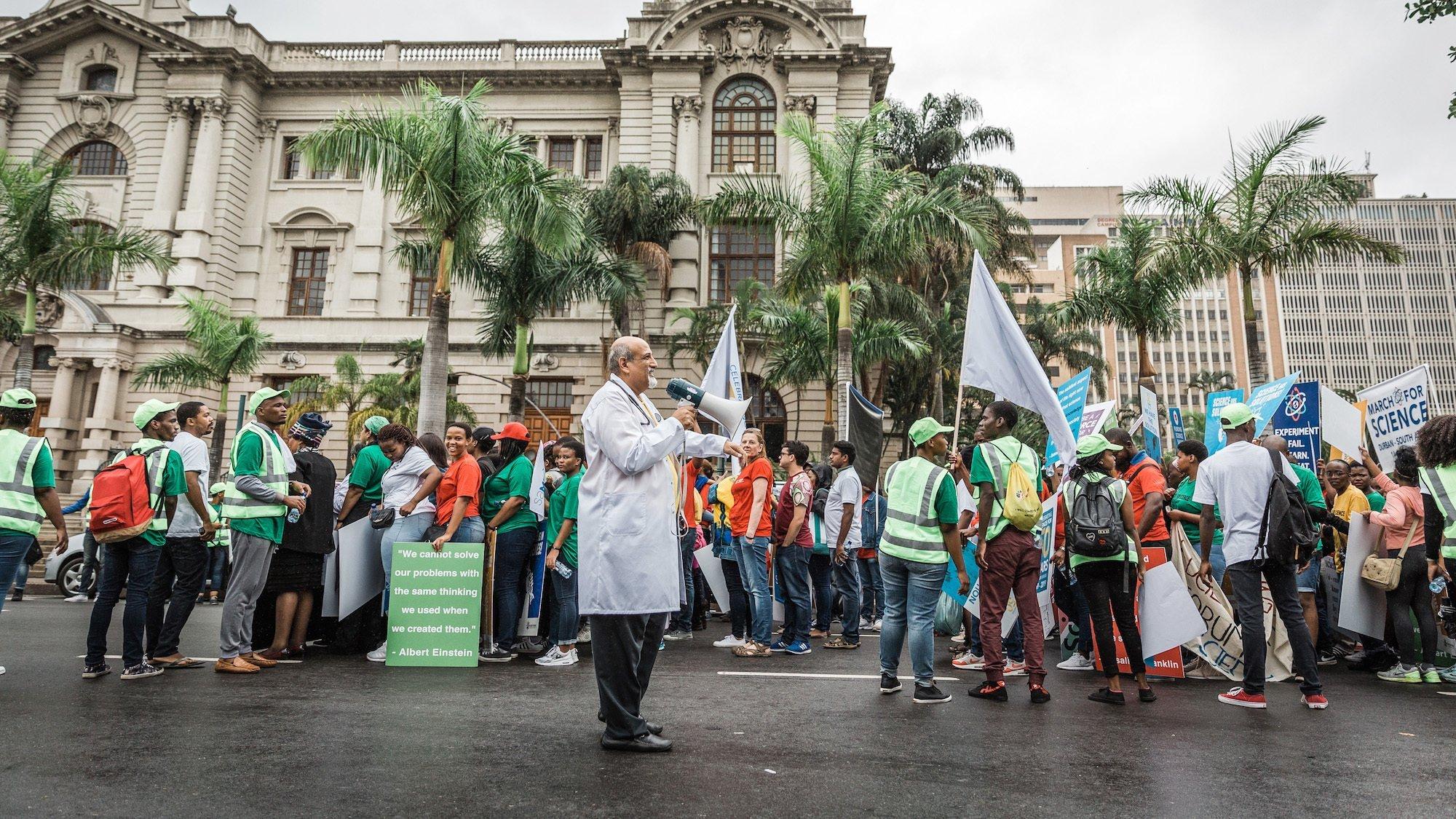 Scientist Professor Salim Abdool Karim, a South African epidemiologist and infectious diseasaes specialist, and one of the conveners of the march leads people during the 'March for Science' in Durban on April 14, 2018. – The march was organised by the University of KwaZulu-Natal (UKZN), the South African Medical Research Council (SAMRC), the South African Medical Students Association (SAMSA), the Centre for the AIDS Programme of South Africa (CAPRISA), and Global Laboratories. (Photo by RAJESH JANTILAL / AFP)