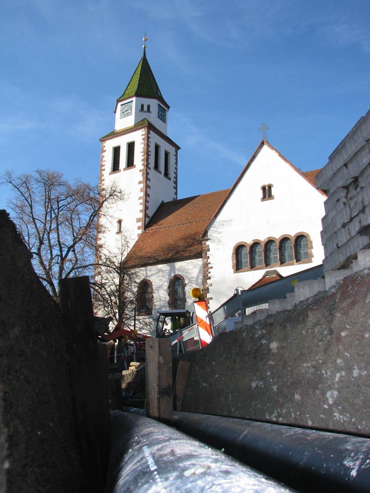 Verlegung einer Wärmeleitung. Im Hintergrund ist eine Kirche zu sehen