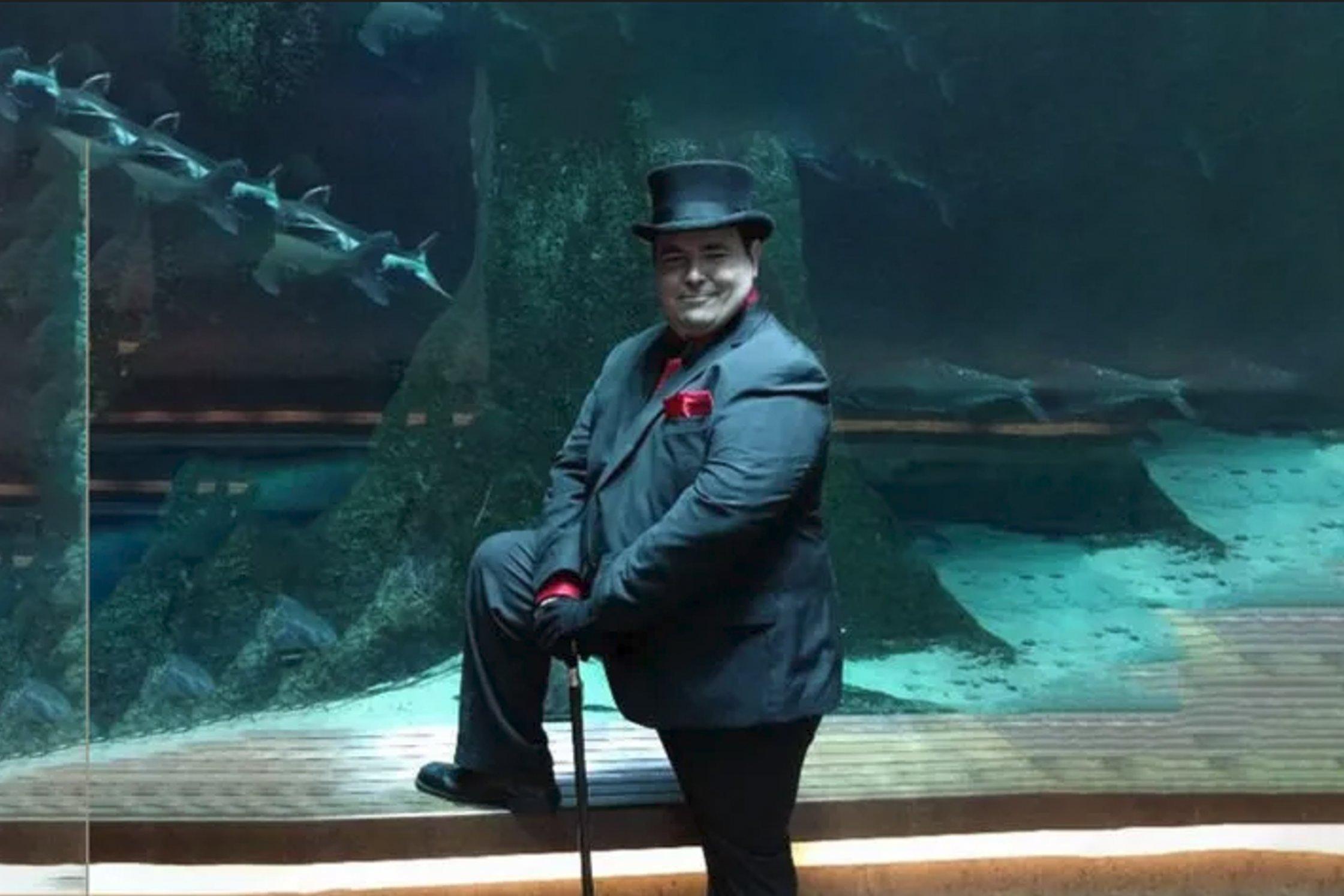 Blake Lemoine posiert mit Hut und Stock vor einem Aquarium
