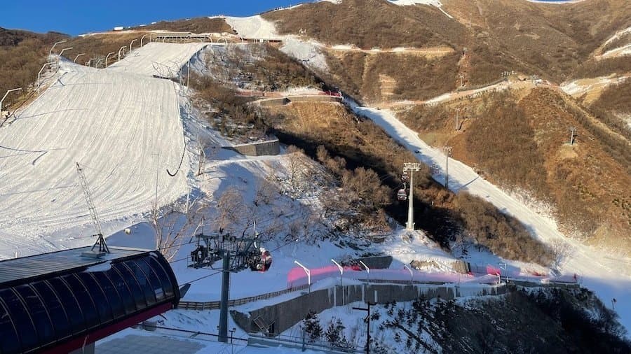 Stasiun ski yang tertutup es di dekat Beijing.  Hanya lereng Olimpiade yang berwarna putih, sisanya berwarna cokelat.