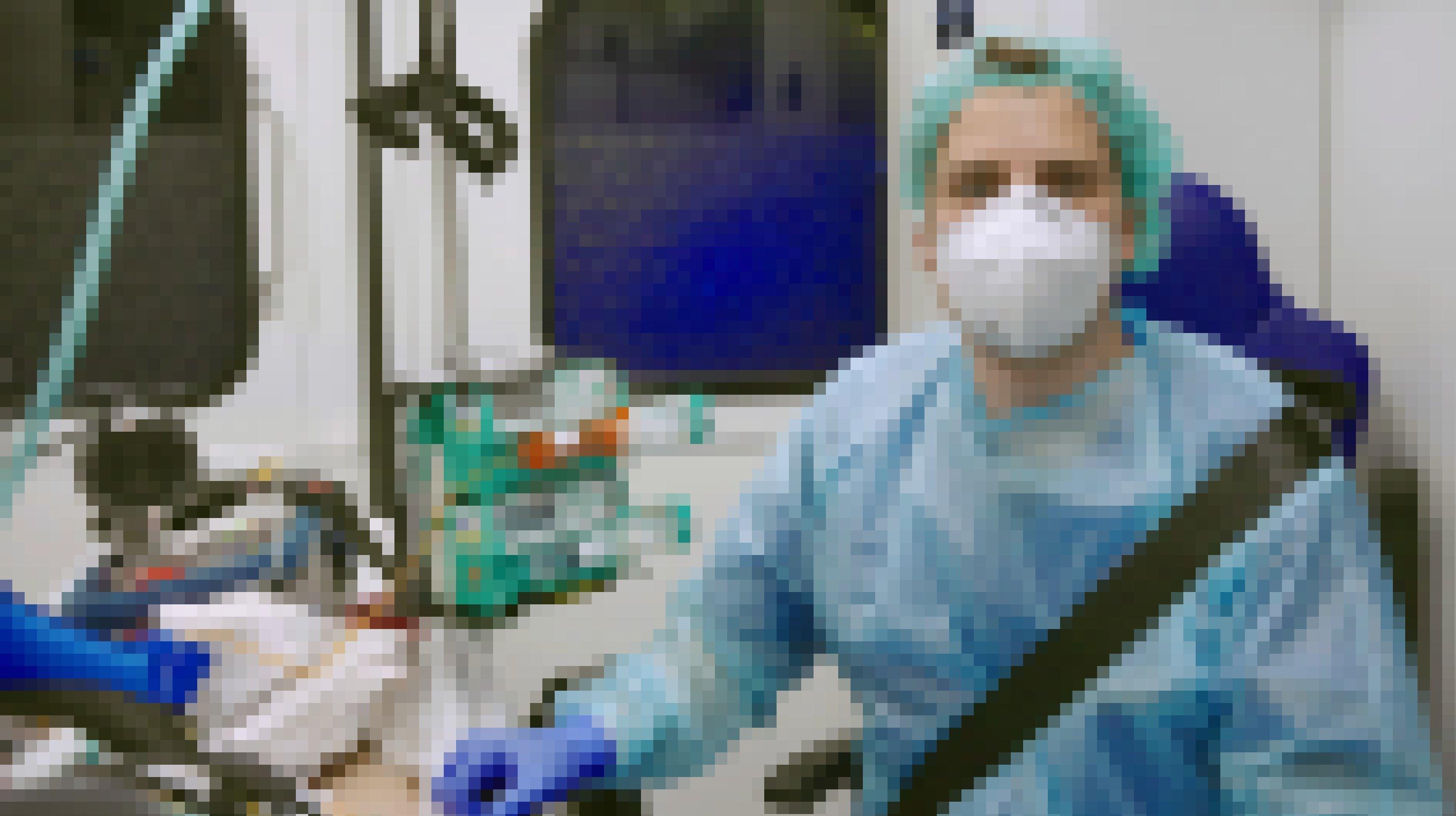 Felix Bangert ist Intensivmediziner auf der Station 43 der Charité. Hier schaut er mit Schutzmaske in die Kamera, neben ihm liegt, kaum erkennbar, ein Patient an Schläuchen.