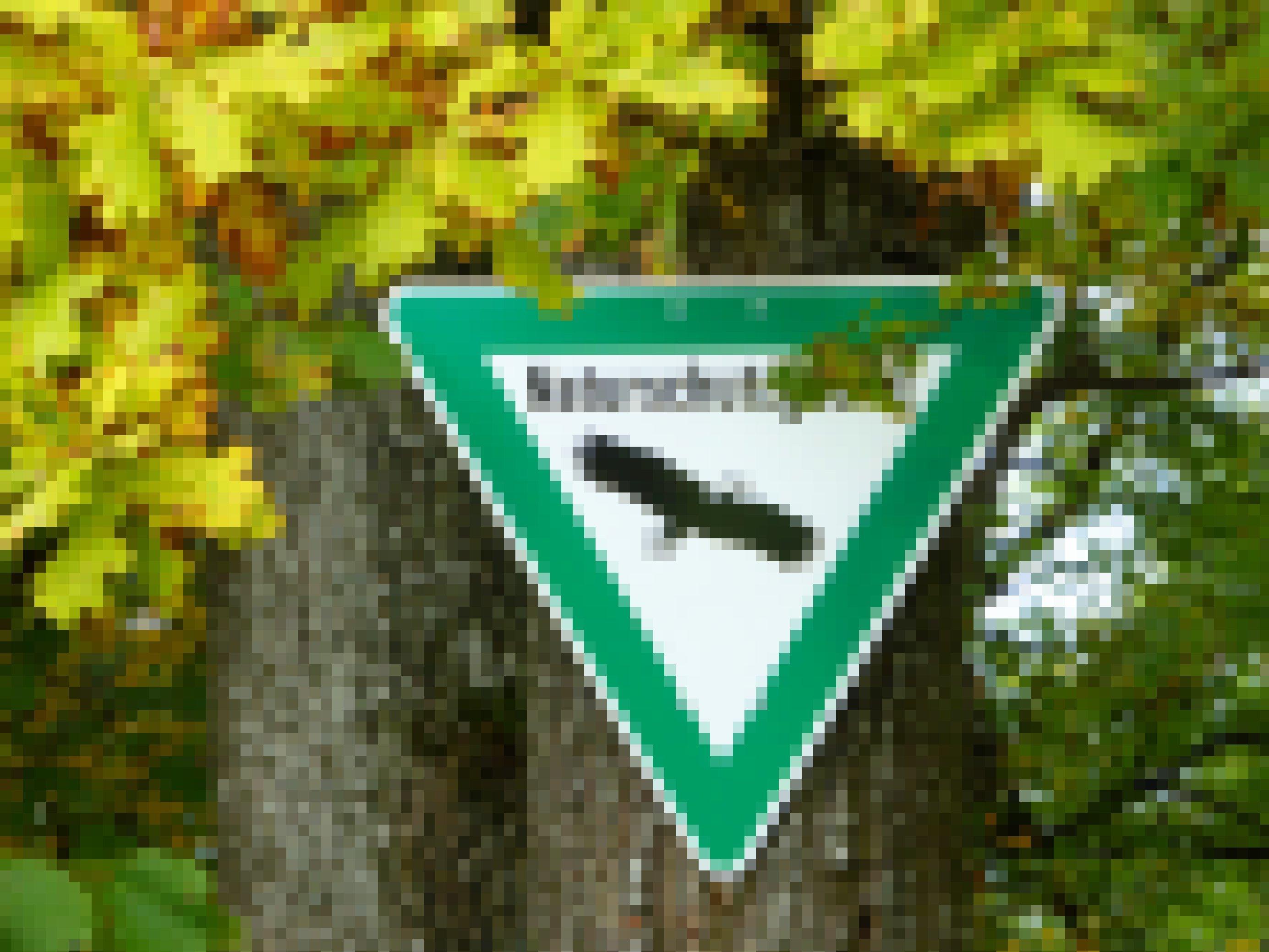 Offizielles Naturschutzgebiets-Schild, grün umrandetes auf dem Kopf stehendes Dreieck mit dem Schema eines Weißkopfseeadlers, umrahmt von sich herbstlich verfärbenden Eichenblättern.