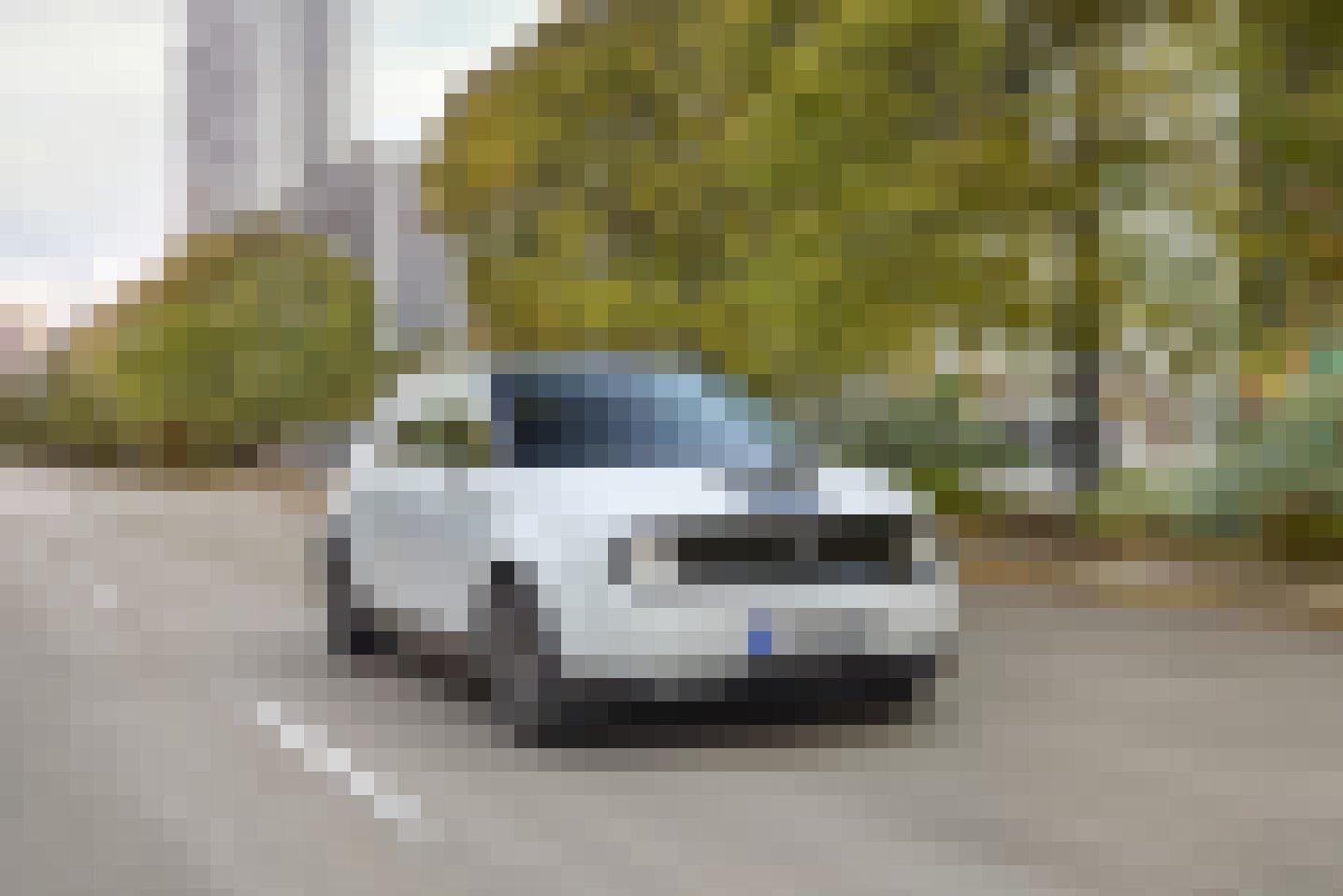 Ein kleines weißes Elektroauto fährt durch die Stadt.