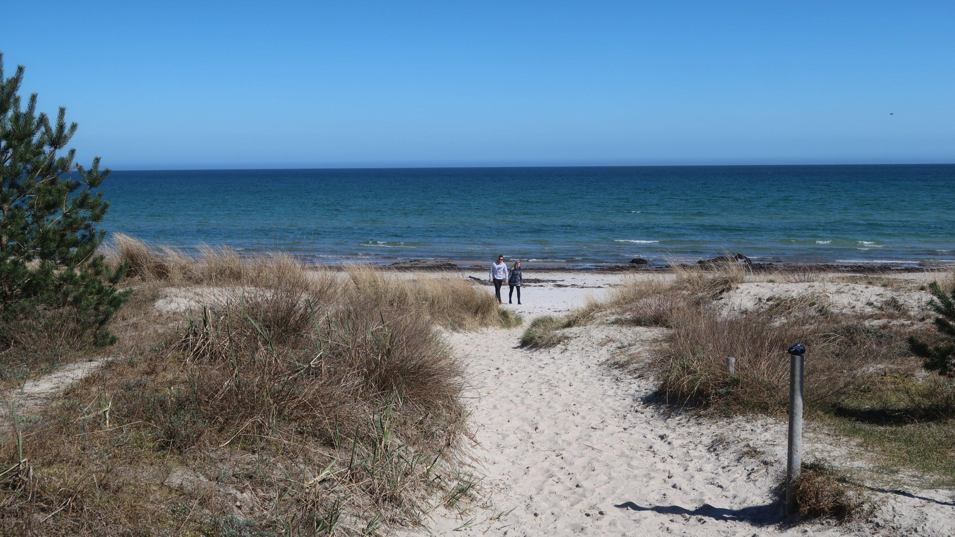 Paar geht am Strand spazieren.