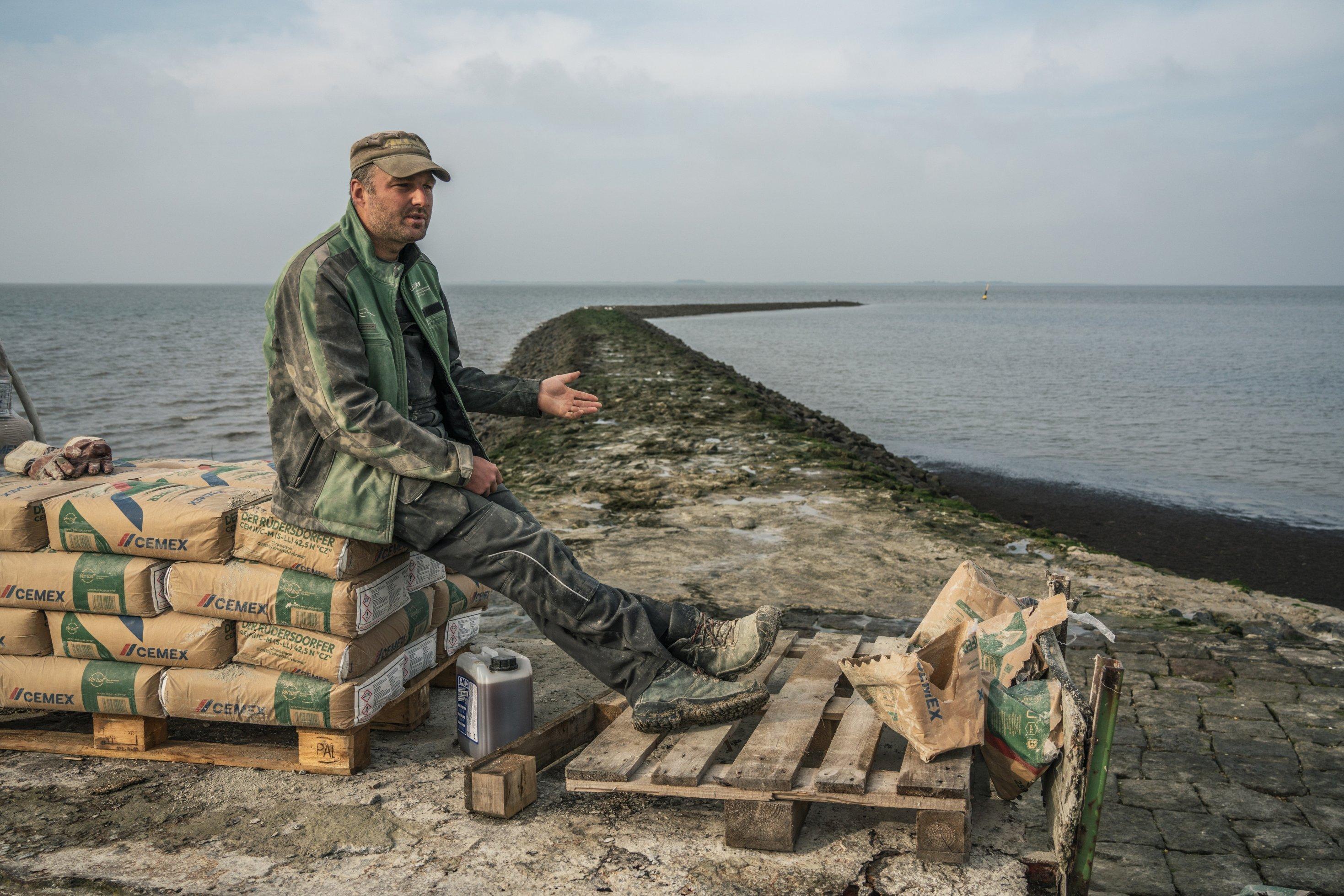 Mann sitzt auf einigen Säcken mit Zement