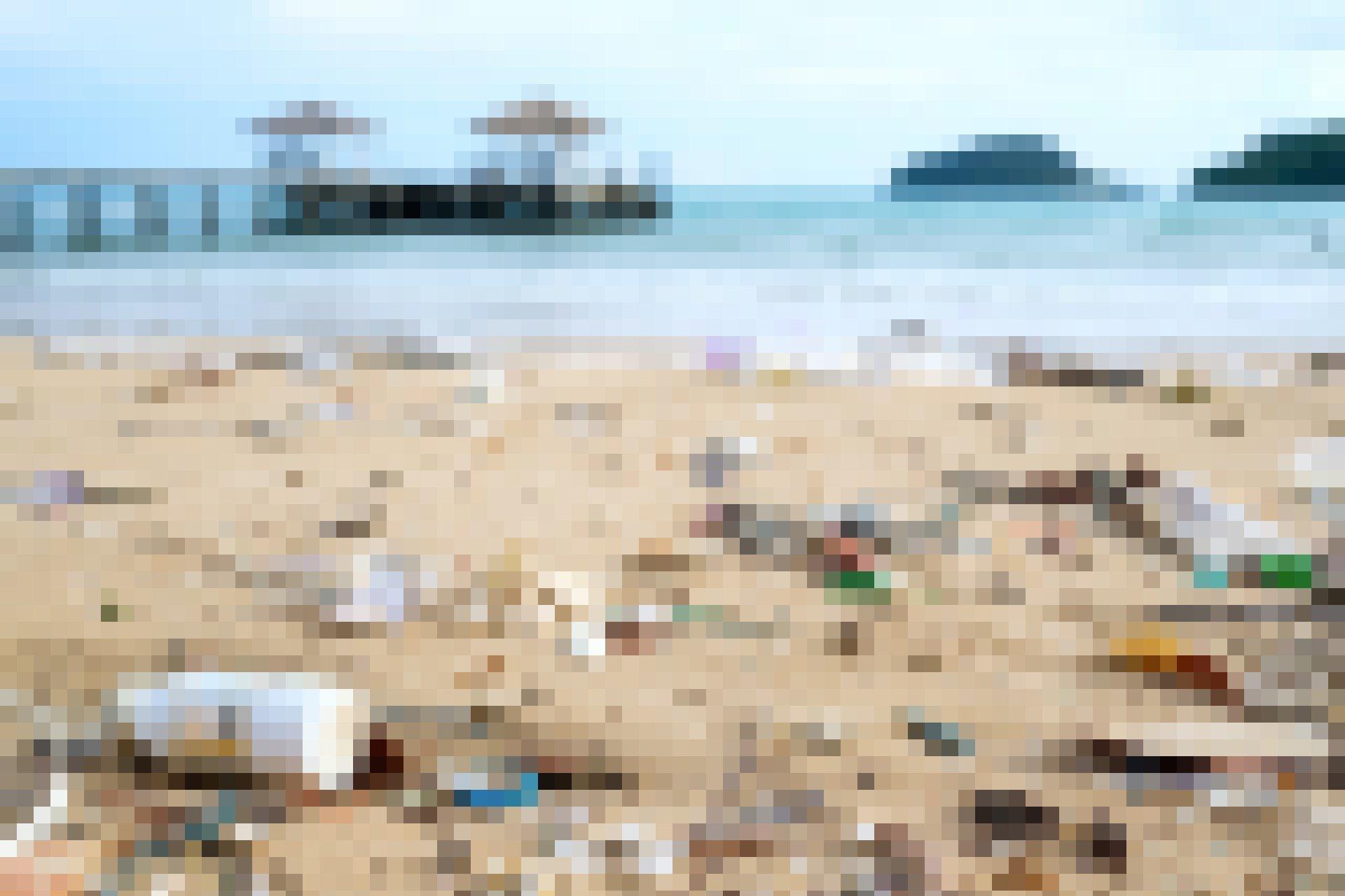 Plastikmüll am Strand vor einem Horizont mit einem Steg.