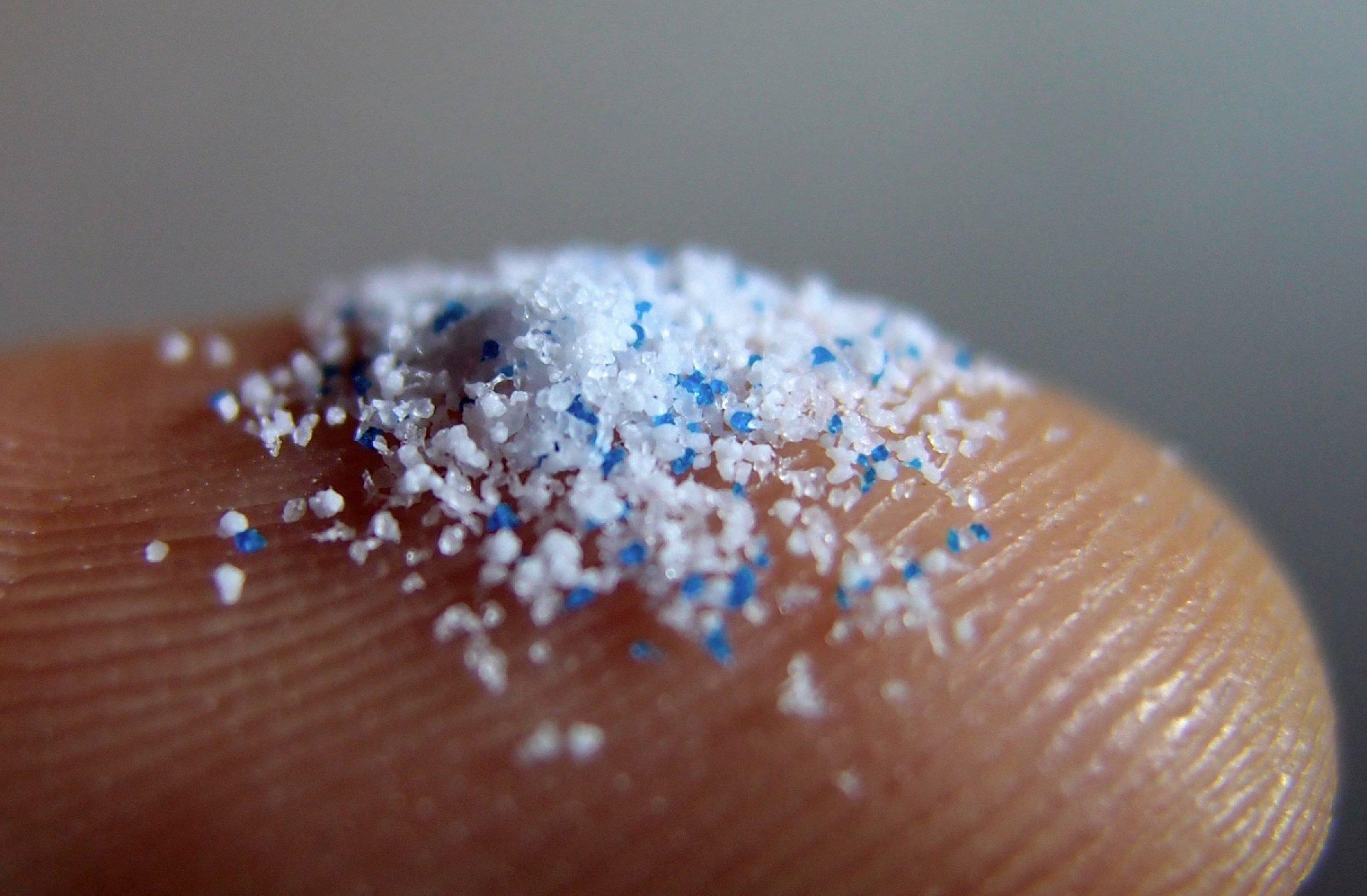 Kleinste Plastikpartikel auf einer Fingerspitze