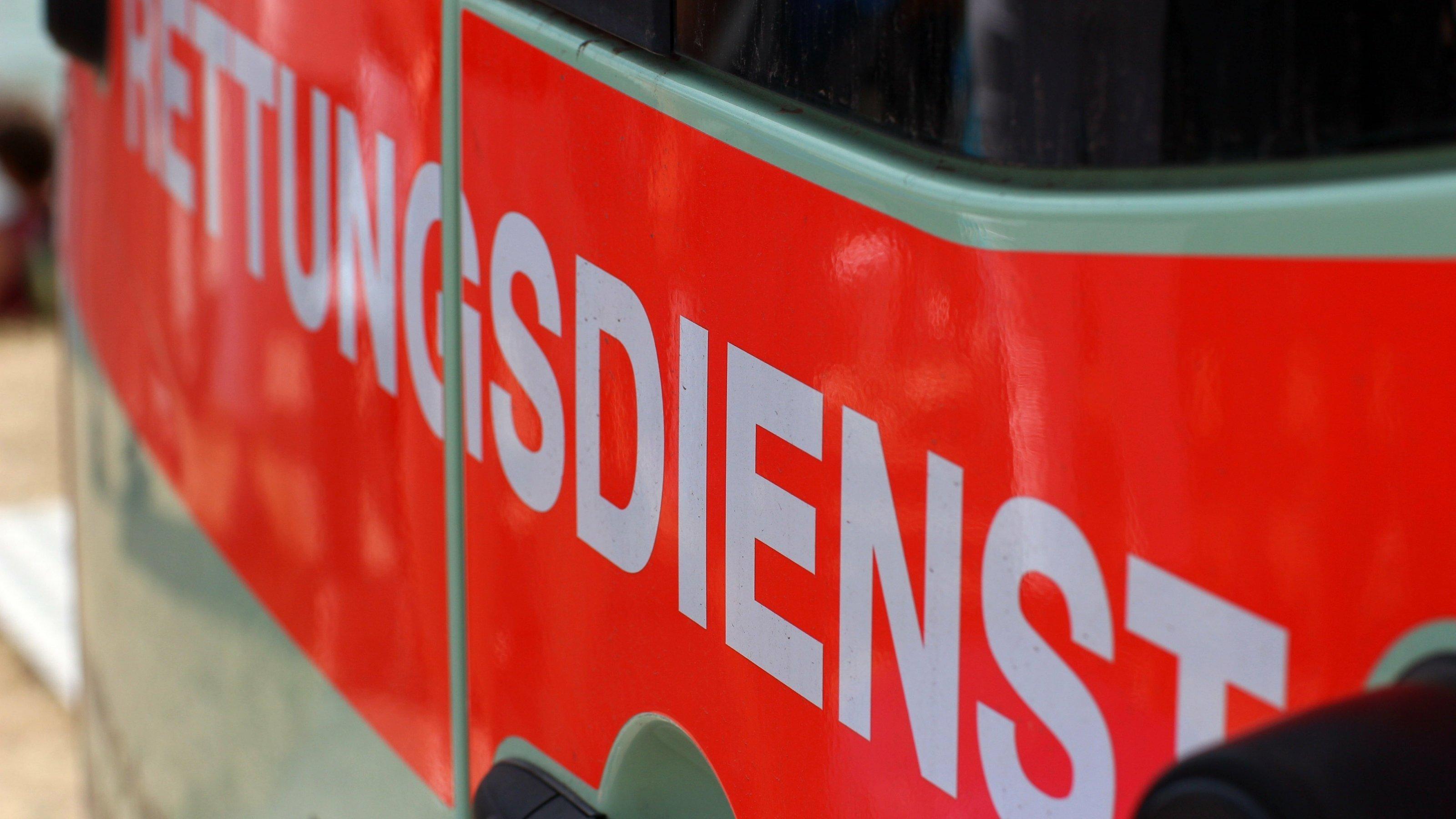 Die leuchtend orangefarbene Aufschrift „Rettungsdienst“ auf einem Krankenwagen
