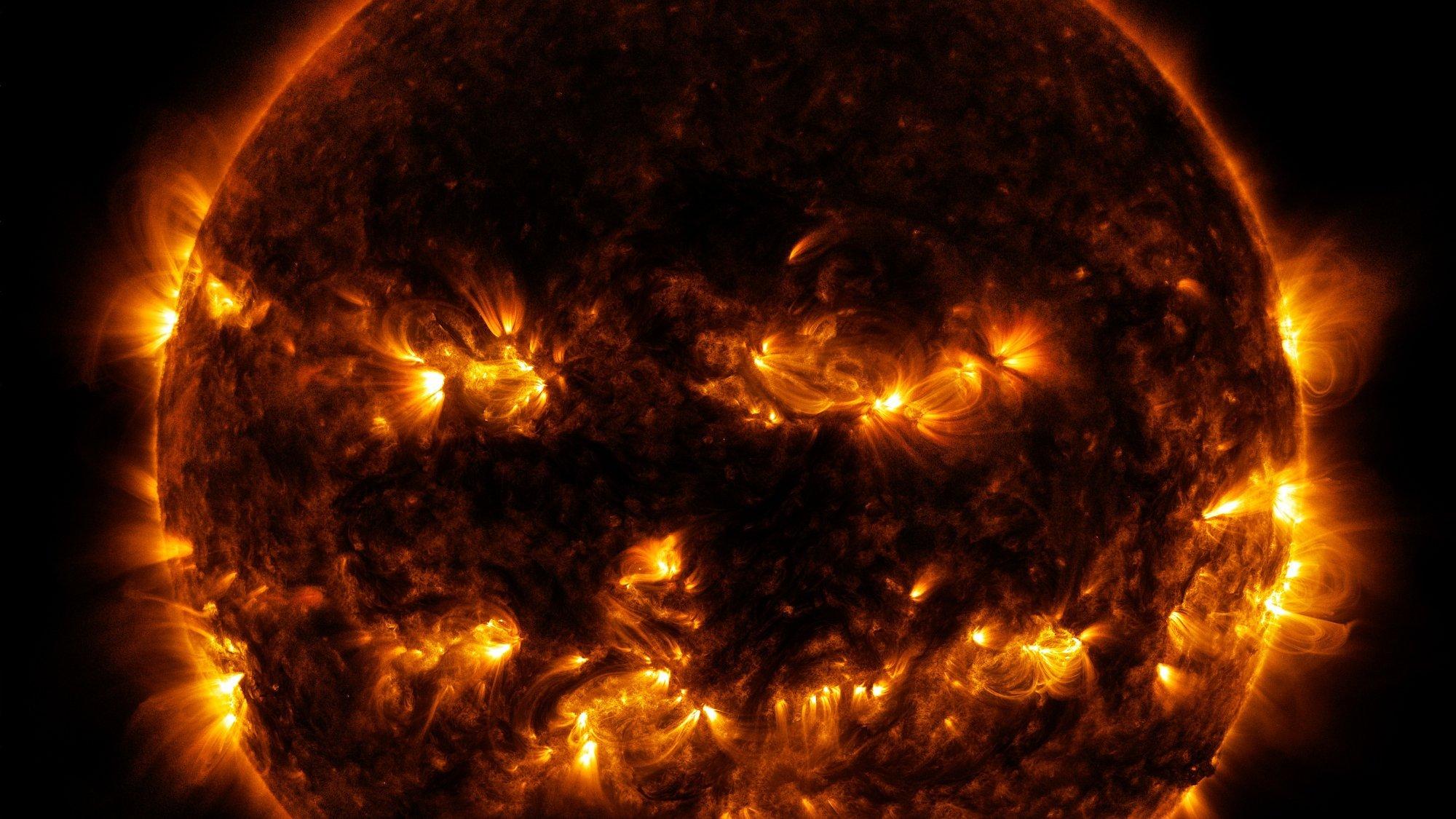 Die Sonne sieht im von einer Raumsonde aufgenommenen Wellenlängenbereich fremd aus: ein Teil ihrer Oberfläche ist dunkel, andere treten hell hervor. So wirkt sie wie ein Kürbis mit einem ausgeschnittenenen Grinsegesicht.