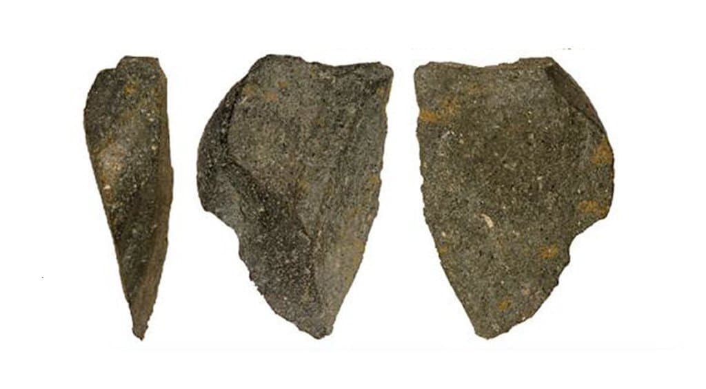 Zu sehen sind drei Ansichten eines 2,6 Millionen Jahre alten Steinwerkzeugs von der Fundstätte Bokol Dora in Äthiopien. Es handelt sich um einen gräulichen Stein, der nach unten spitz zu läuft und einst als Werkzeug gedient hat. Forscher glauben, dass Frühmenschen dieses Werkzeug nach einem bestimmten Plan gezielt angefertigt haben.