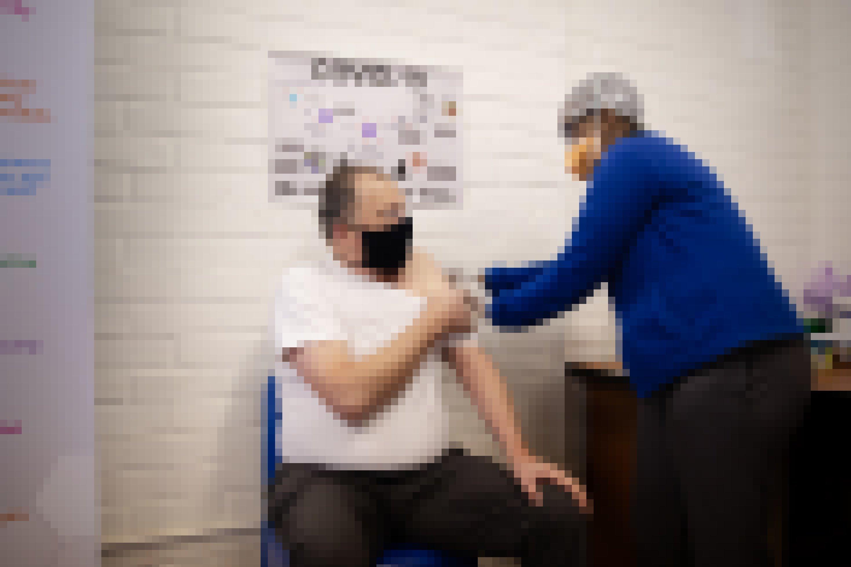 Professor Martin Veller bekommt die Injektion mit der Impfung bzw dem Placebo, er trägt eine Maske, ebenso wie der Mitarbeiter, der ihm die Spritze gibt.