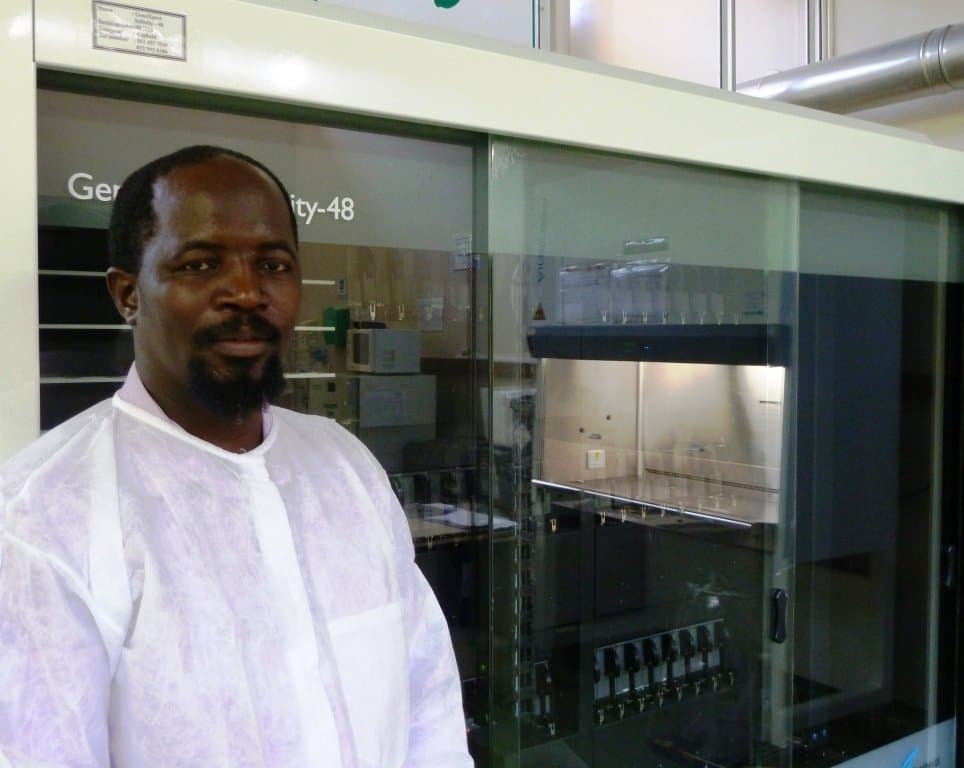 Labortechniker Justice Mzimela steht mit weißem Kittel in einem Labor bei Durban