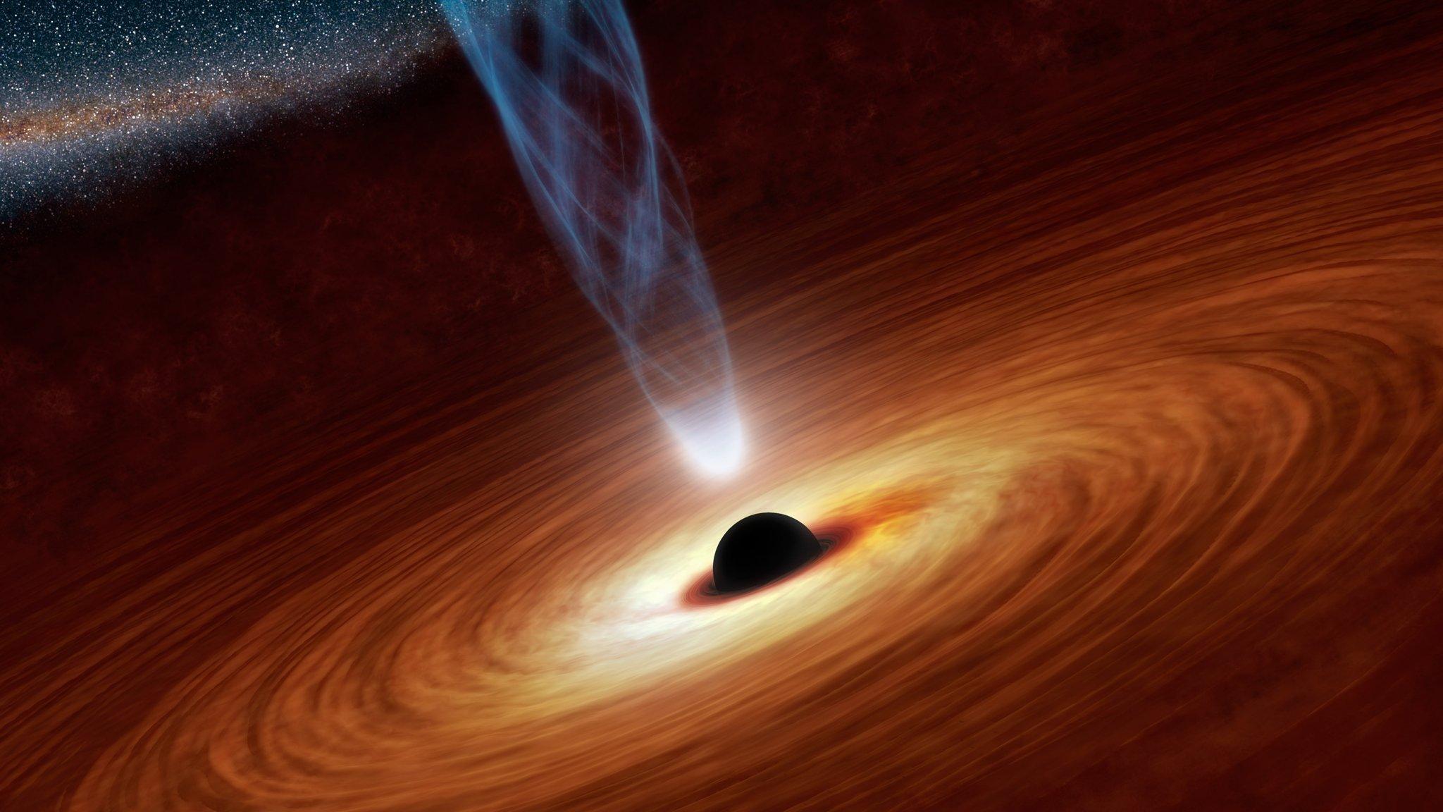 Hier ist die künstlerische Darstellung eines extrem massereichen Schwarzen Loches zu sehn, das im Zentrum einer Galaxie sitzt. Es zieht  Materie an, die es sich zum Teil einverleibt, die aber teilweise auch durch komplizierte Vorgänge beschleunigt und als hell strahlenden Jet senkrecht zur Scheibe der Galaxie ins All hinausgeschleudert wird – und dabei fast Lichtgeschwindigkeit erreicht.