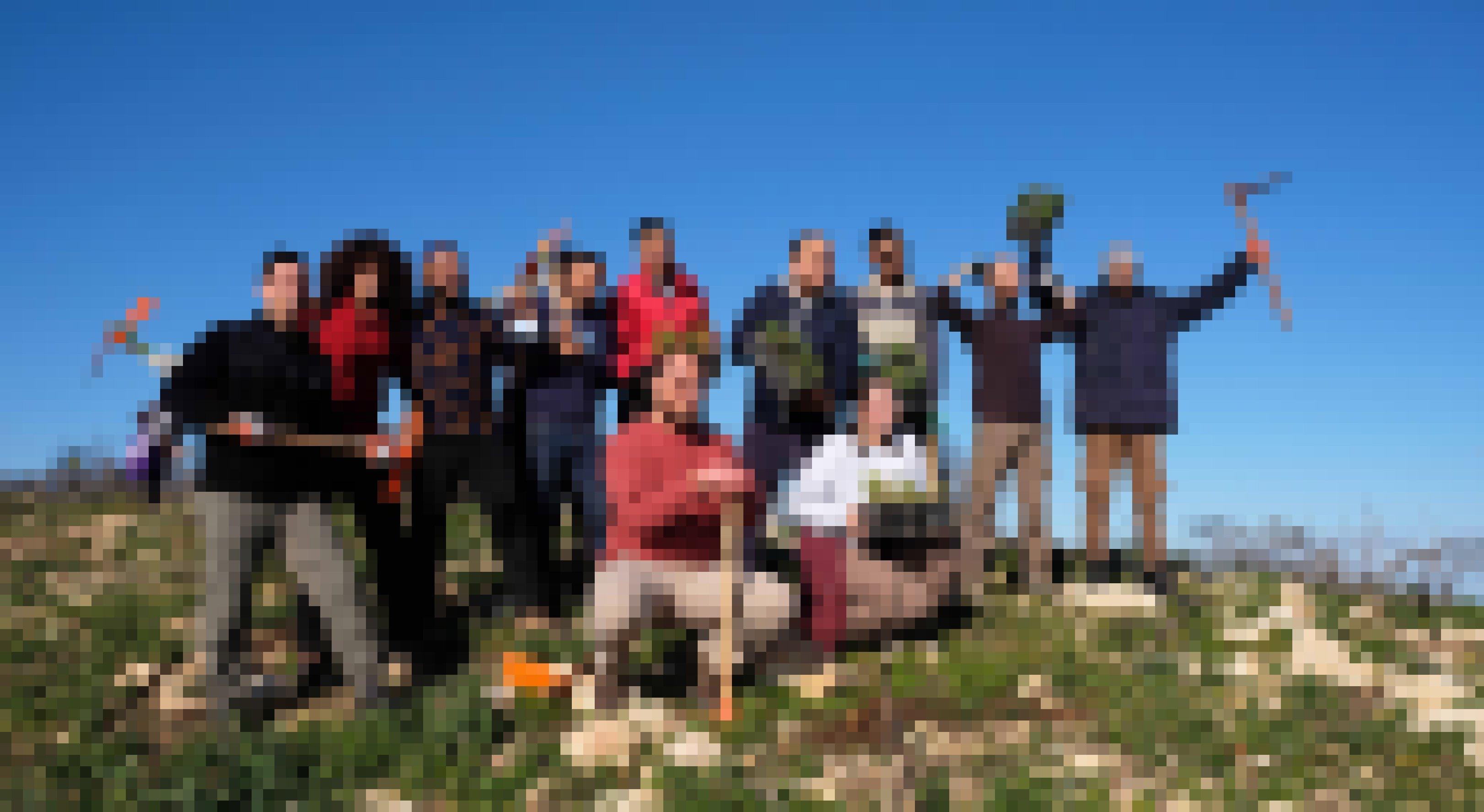 Eine Gruppe junger Leute mit Werkzeug und Setzlingen posiert für ein Foto.