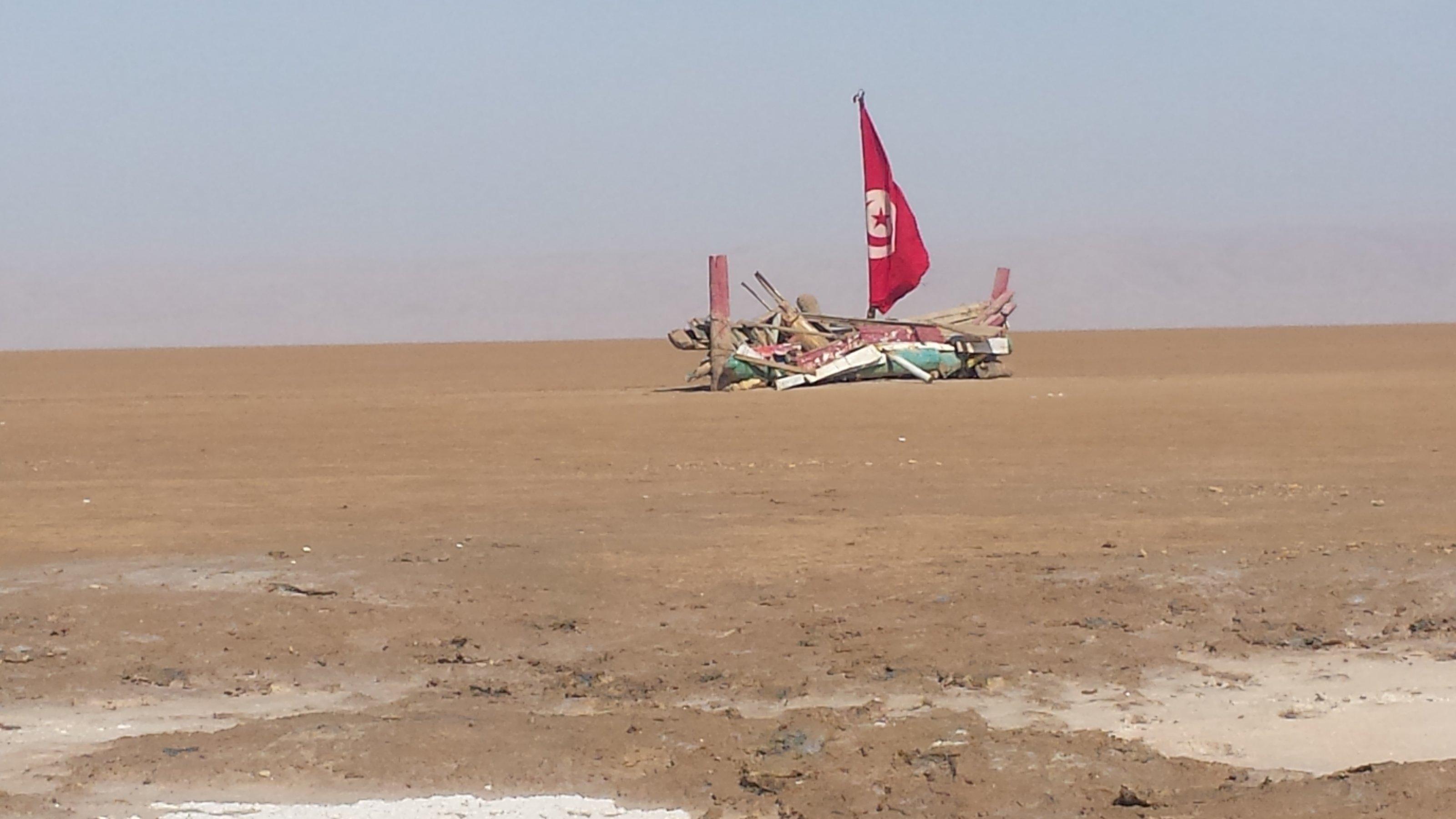 Tunesische Flagge und buntes Schiffswrack im Salzsee Chott El Djerid