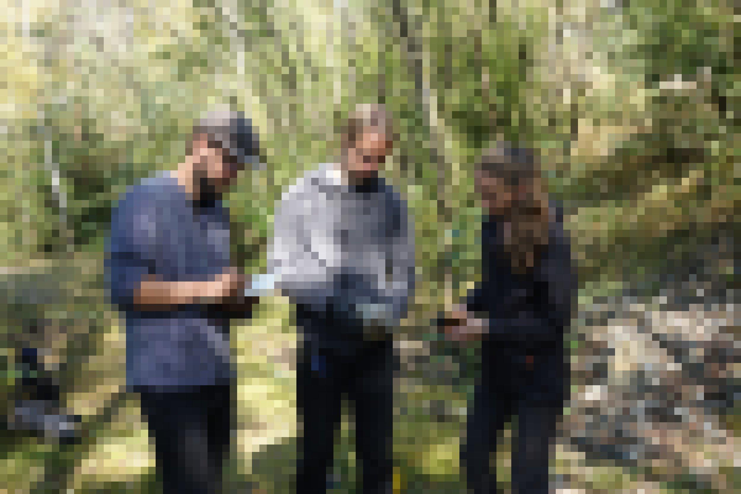 Drei junge Forscher im Freien mit Notizblock und Gestein.