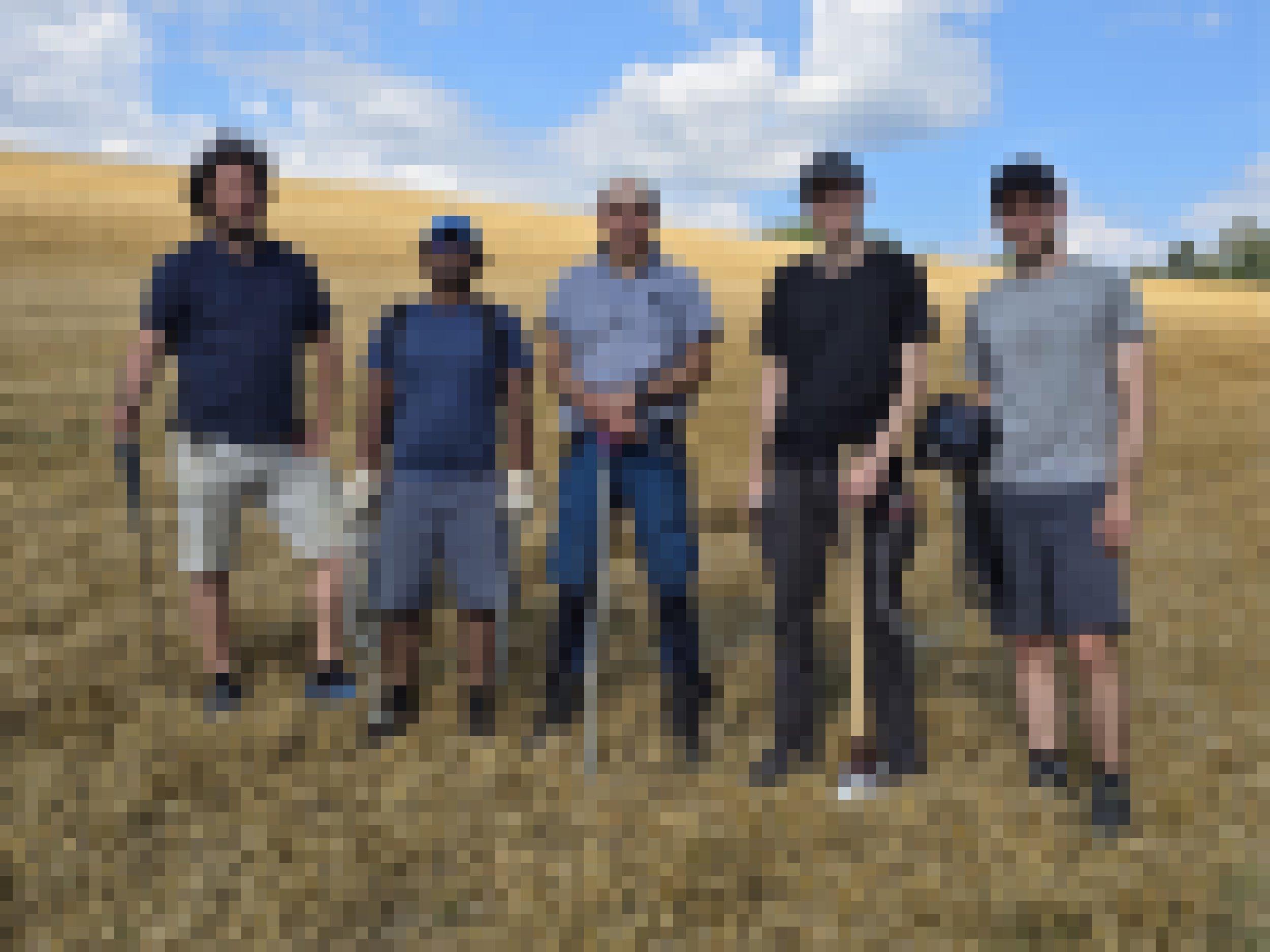 5 Männer auf freiem Feld mit Messgeräten.