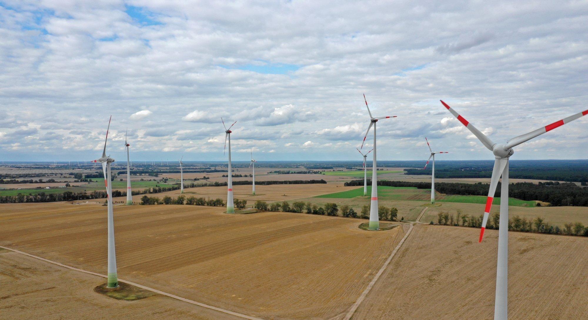 Das Bild zeigt Windräder in einer Agrarlandschaft