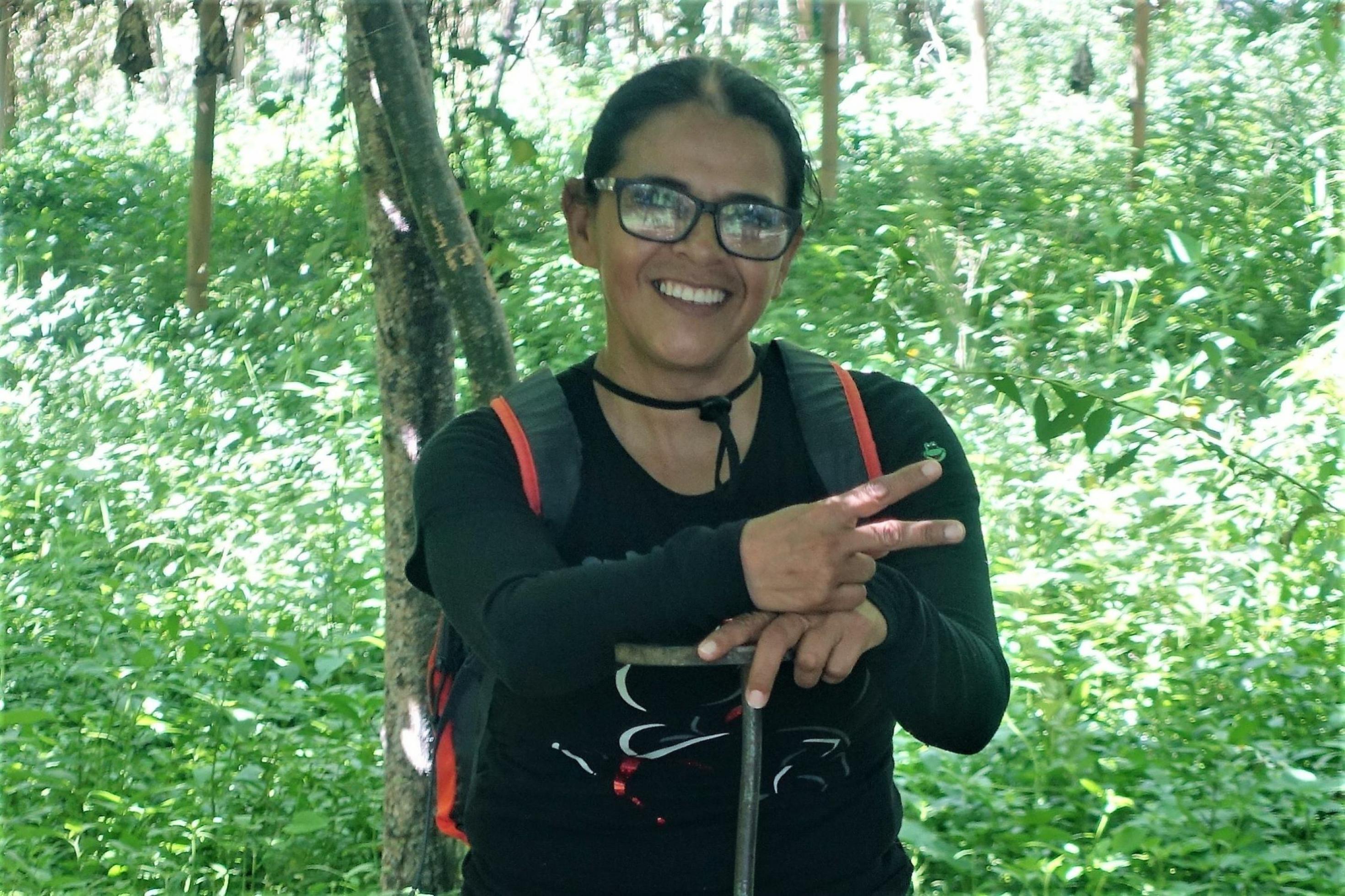eine Frau mit Brille hält ein Peace-Zeichen hoch [AI]