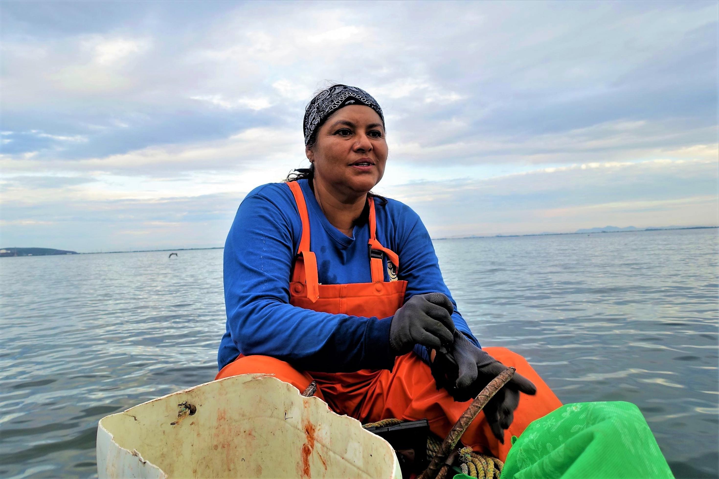 Fischerin Melina Maldonado sitzt auf ihrem Boot und blickt auf die mexikanische Bucht von Ohuira