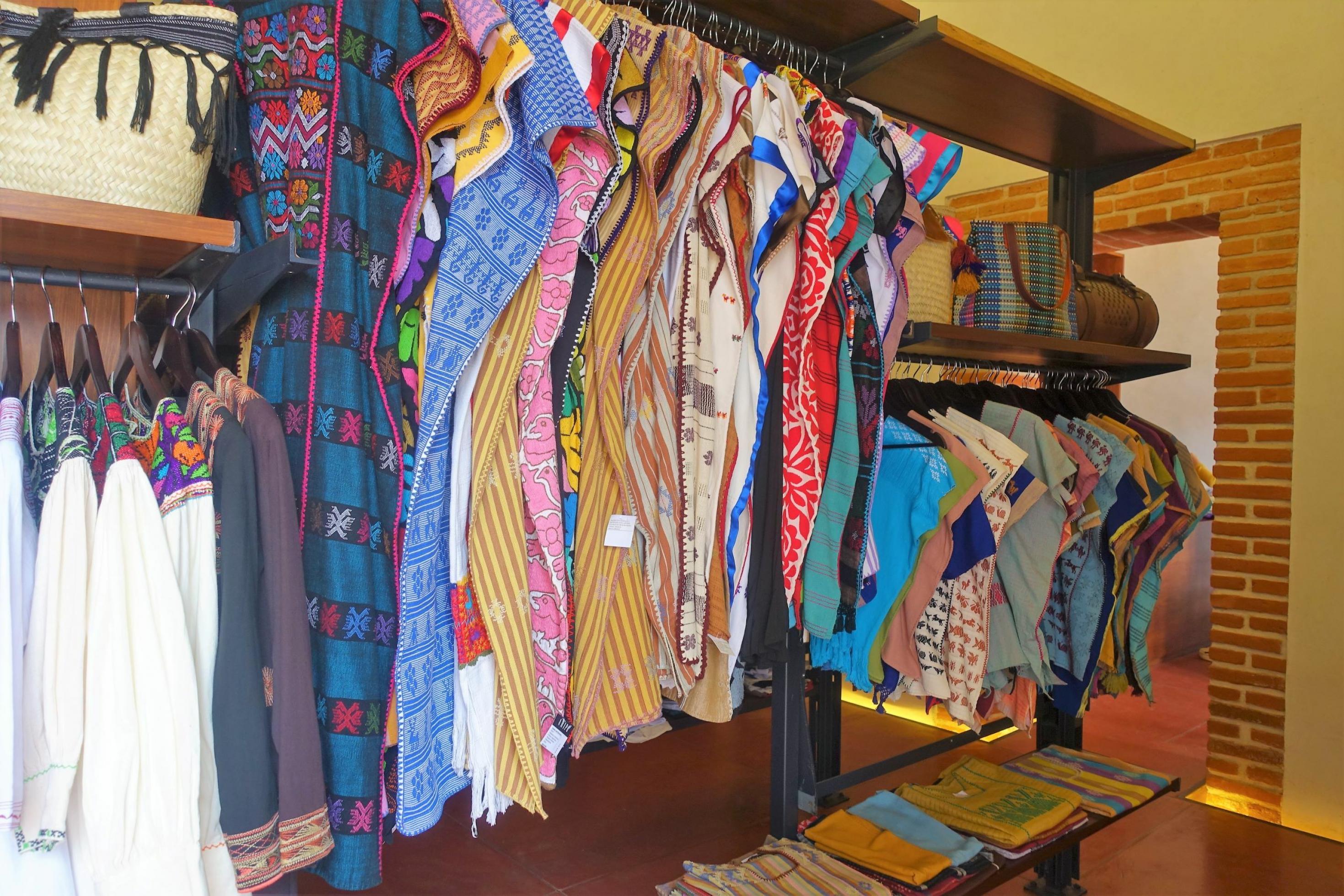 Bunte Kleider hängen zum Verkauf in einem Laden
