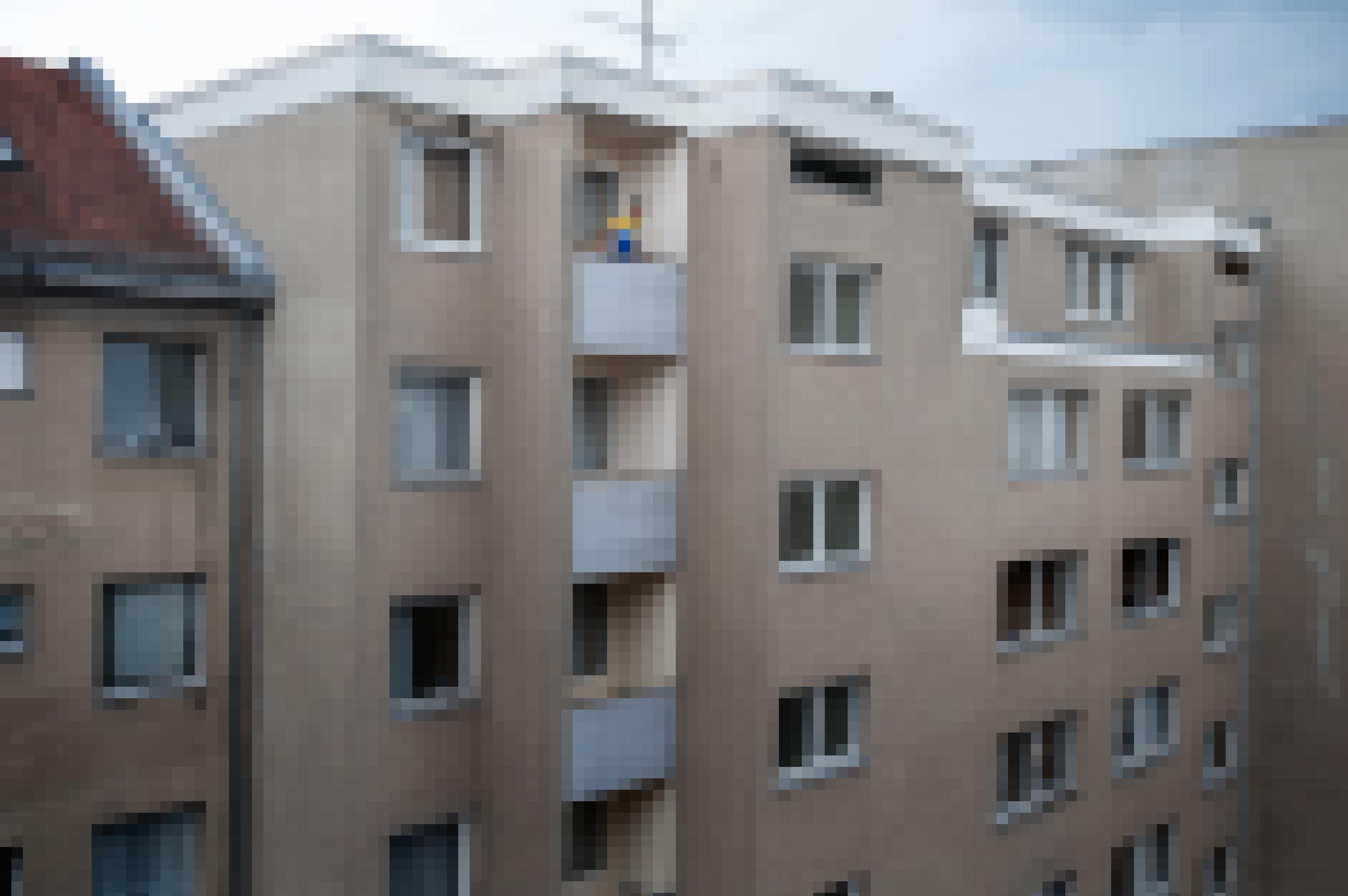 Nazir Jaser schaut von einem Balkon eines mehrstöckigen Wohnblocks nach draußen.
