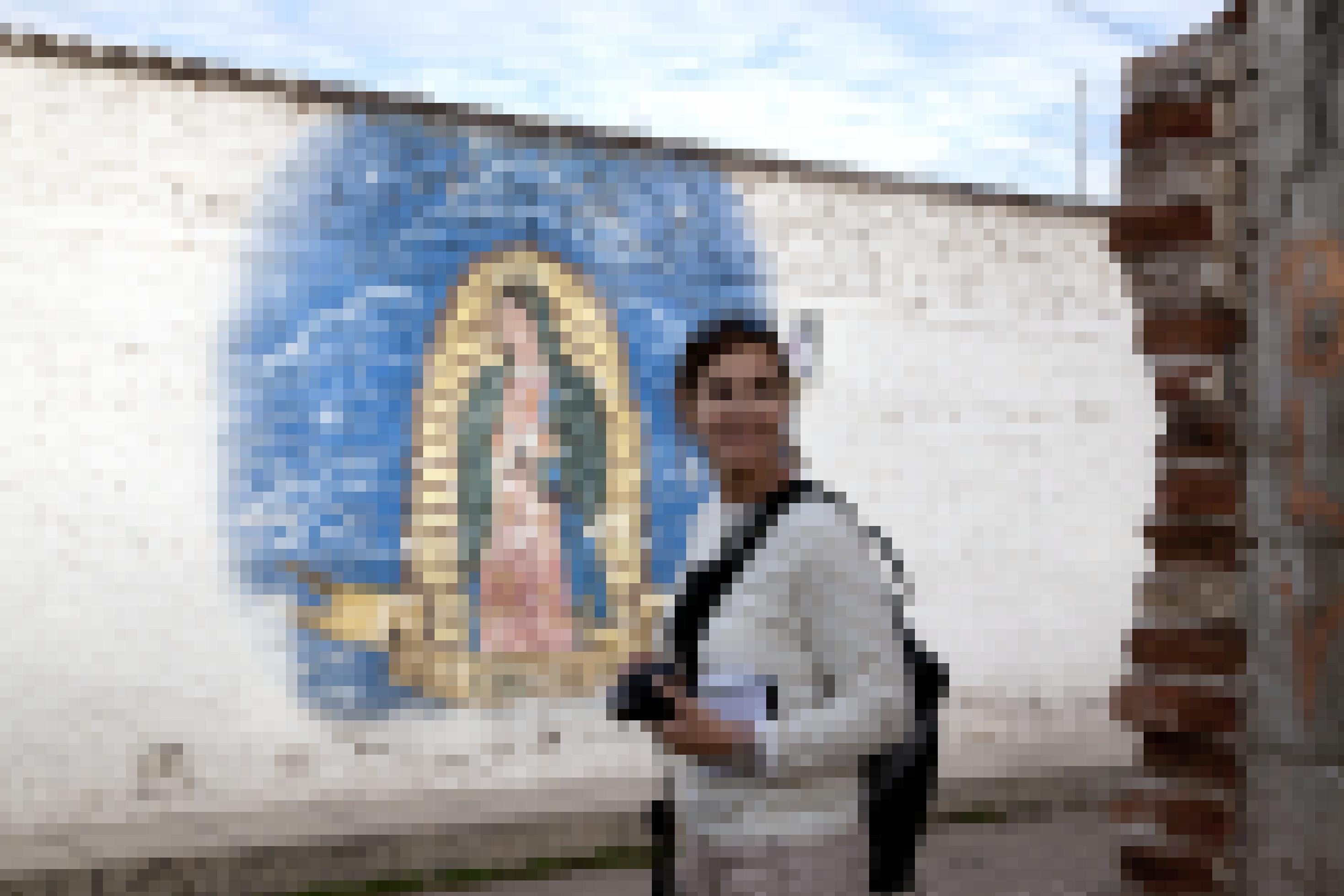 Sandra Weiss mit Fotoausrüstung vor einer mit Graffiti bemalten Wand in Mexiko.