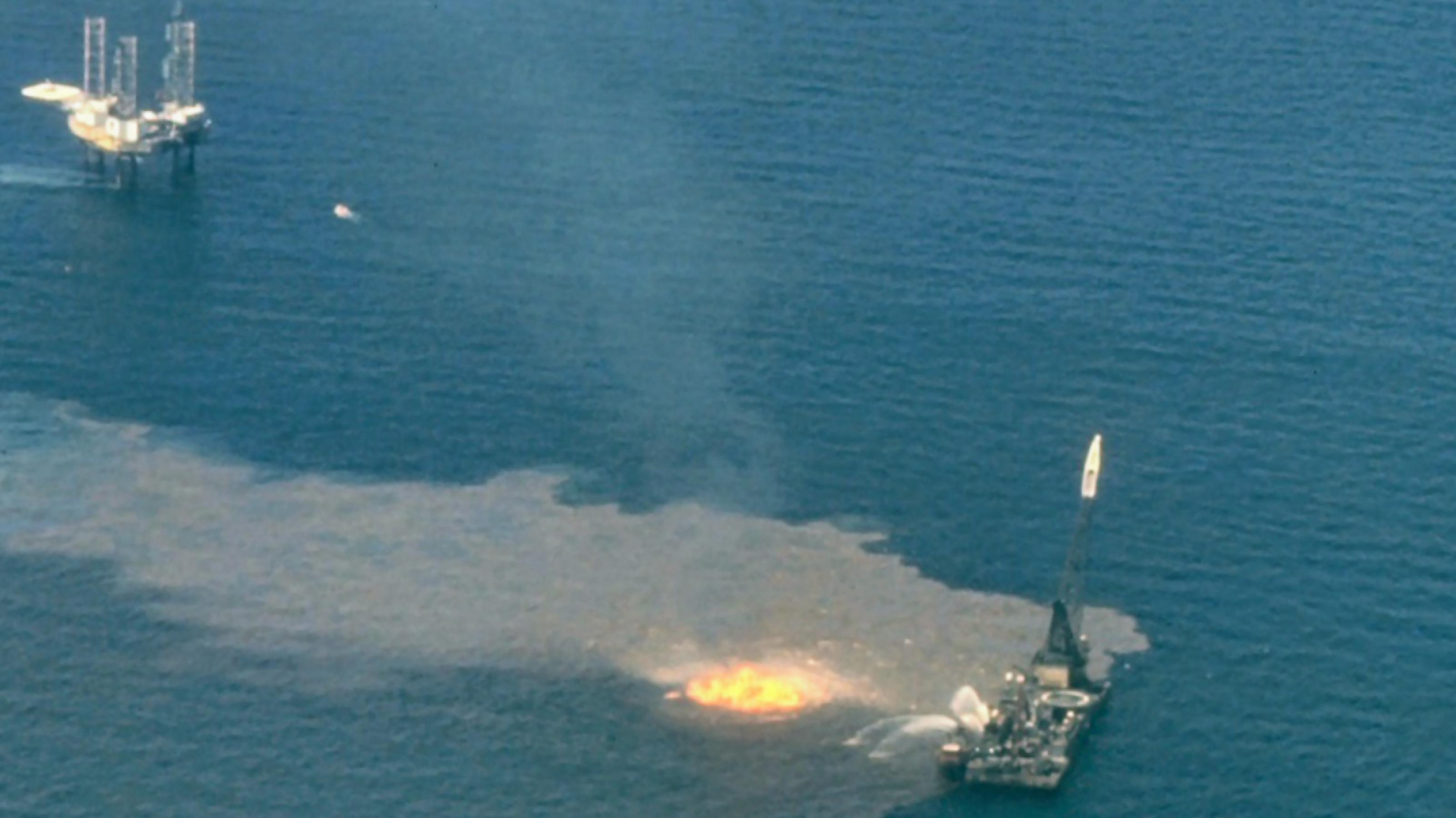 Luftbild von der Unglücksstelle Ixtoc 1, 1979: Öl verschmutzt das Meerwasser und ein Schiff richtet Wasserwerfer auf den Brand.
