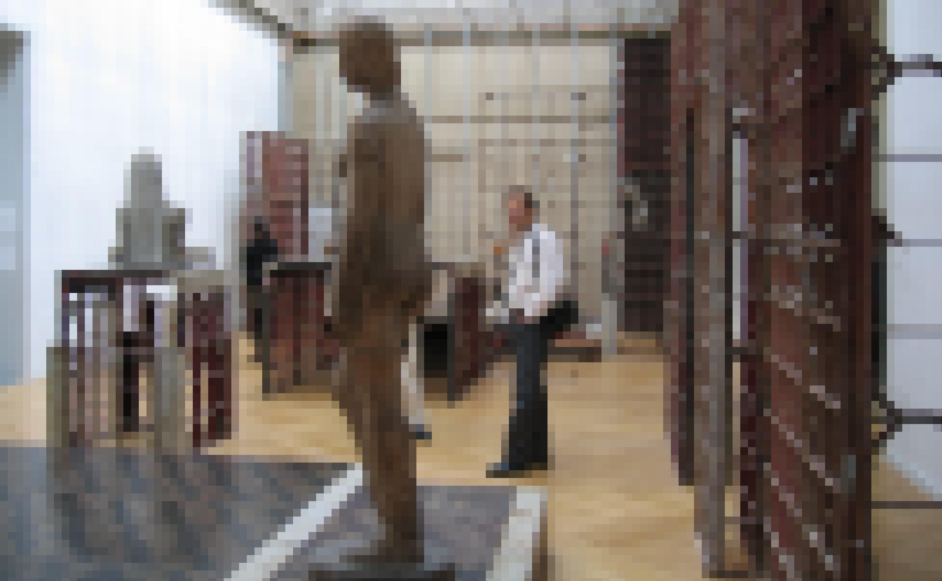 Das Foto zeigt beim Bau übliche Stahlgerüste und Dämmplatten, die in einem Ausstellungsraum als Sockel für figürliche Skulpturen dienen. Im Vordergrund ist eine weibliche Aktdarstellung zu sehen, die von einem Besucher betrachtet wird.