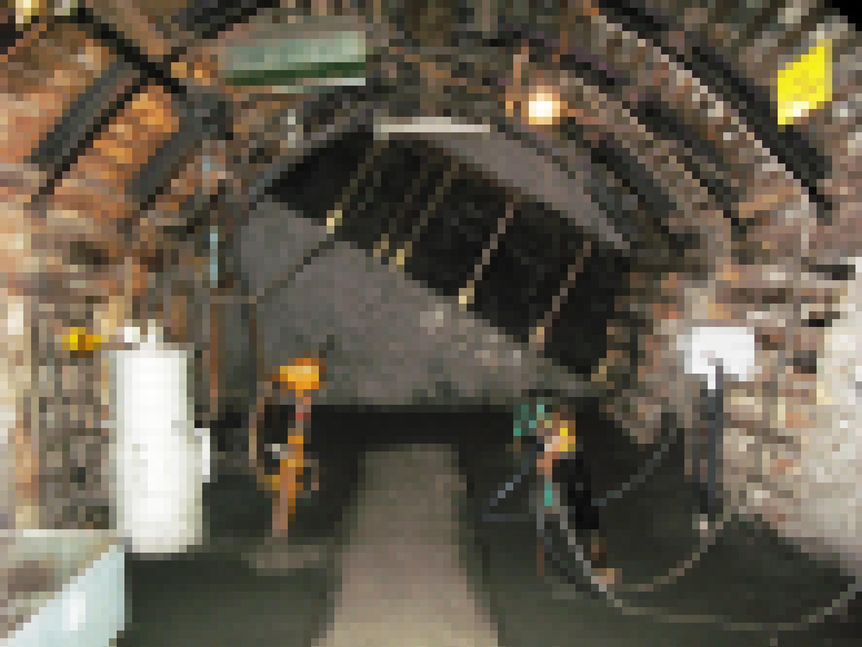 Das Foto zeigt das Innere eines mit Holz ausgekleideten Schachts, im Vordergrund diverse Pumpen und Bohrwerkzeuge.