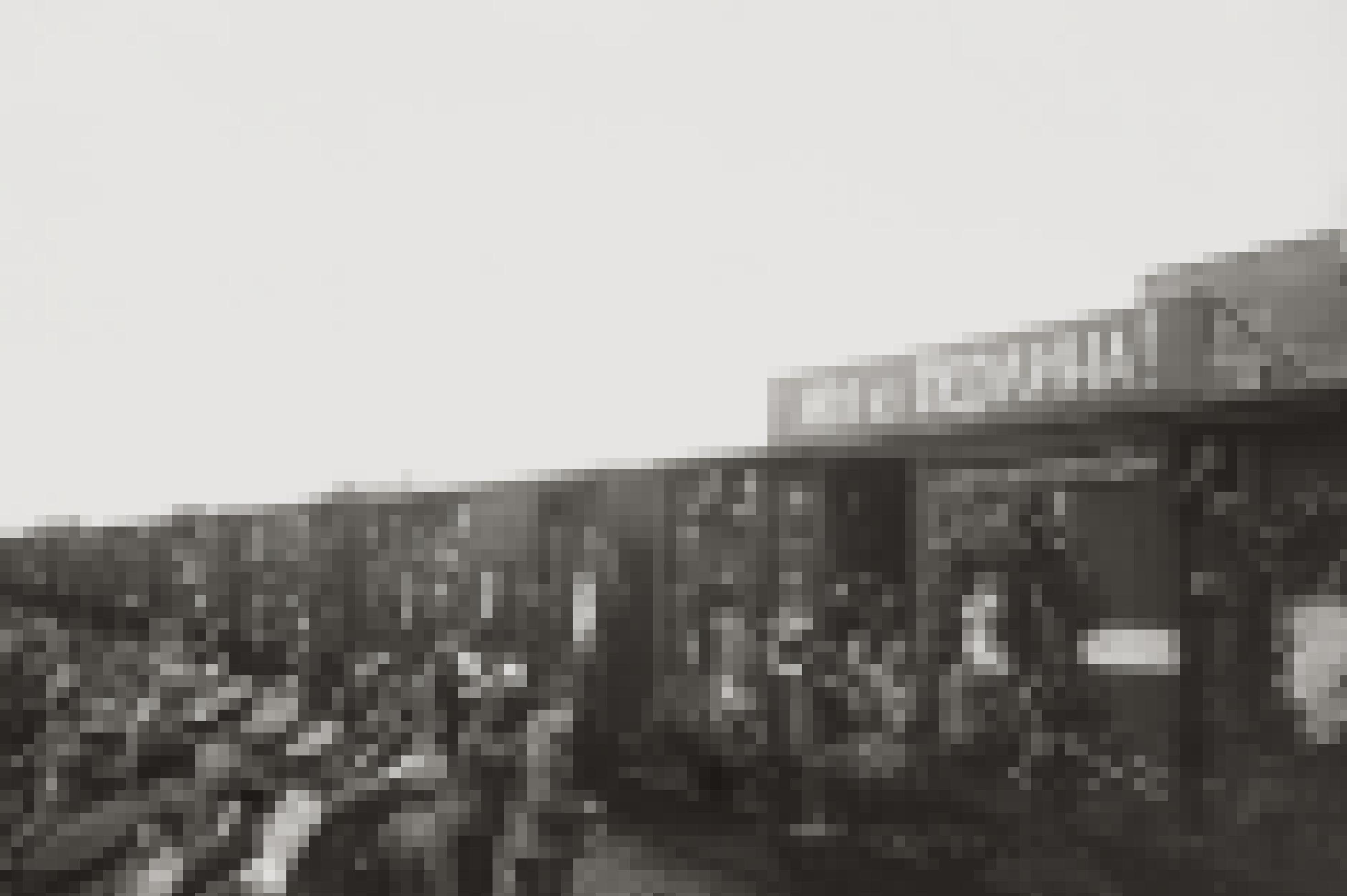 Die Schwarzweissfotografie zeigt einen mit Soldaten überfüllten Zug, auf dessen Wagon ein Schild mit einer russischen befestigt befestigt ist..