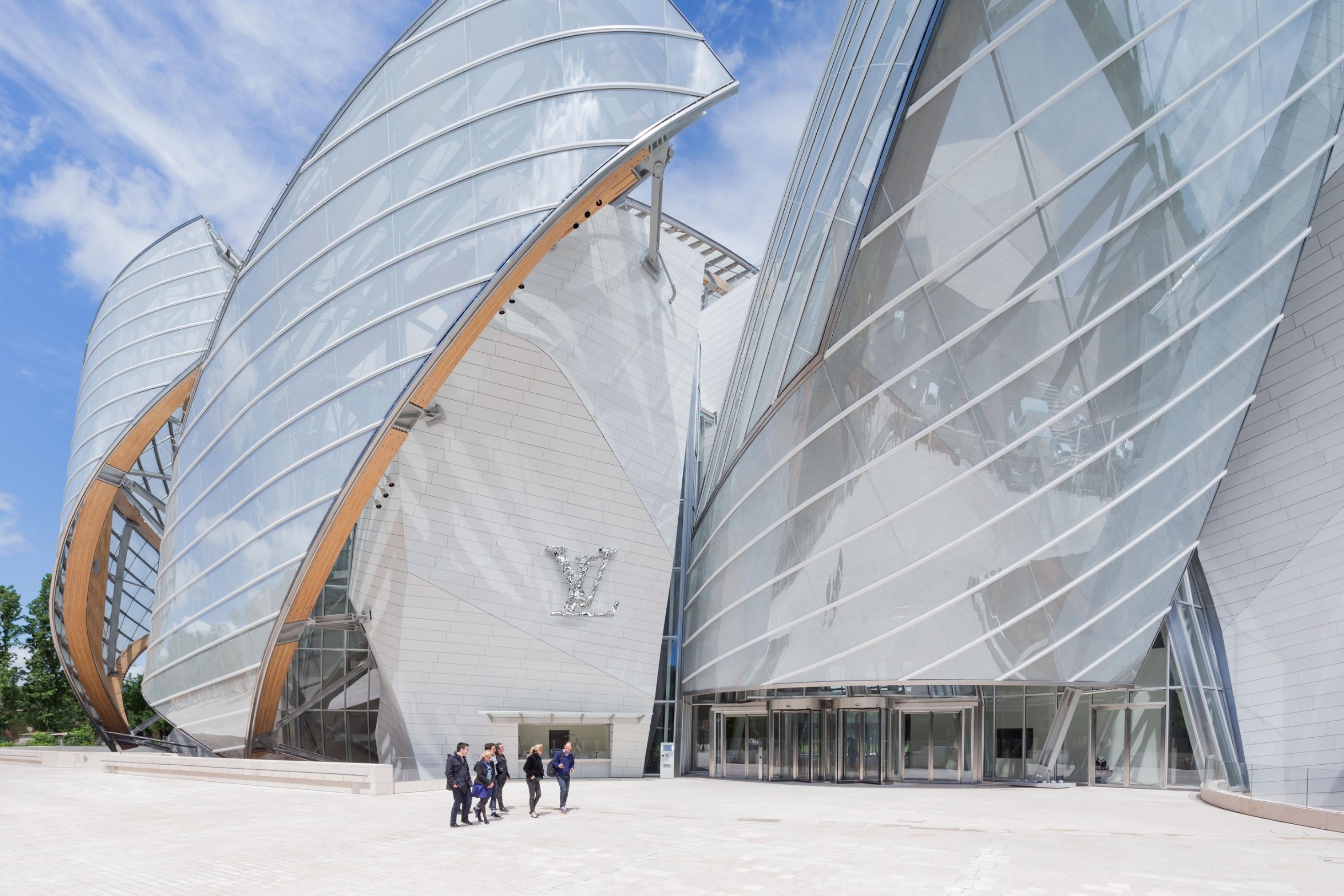 Fassade eines modernen Gebäudes: Lamellenartig übereinander gelegte blattförmige Segmente aus Glas und Stahl.