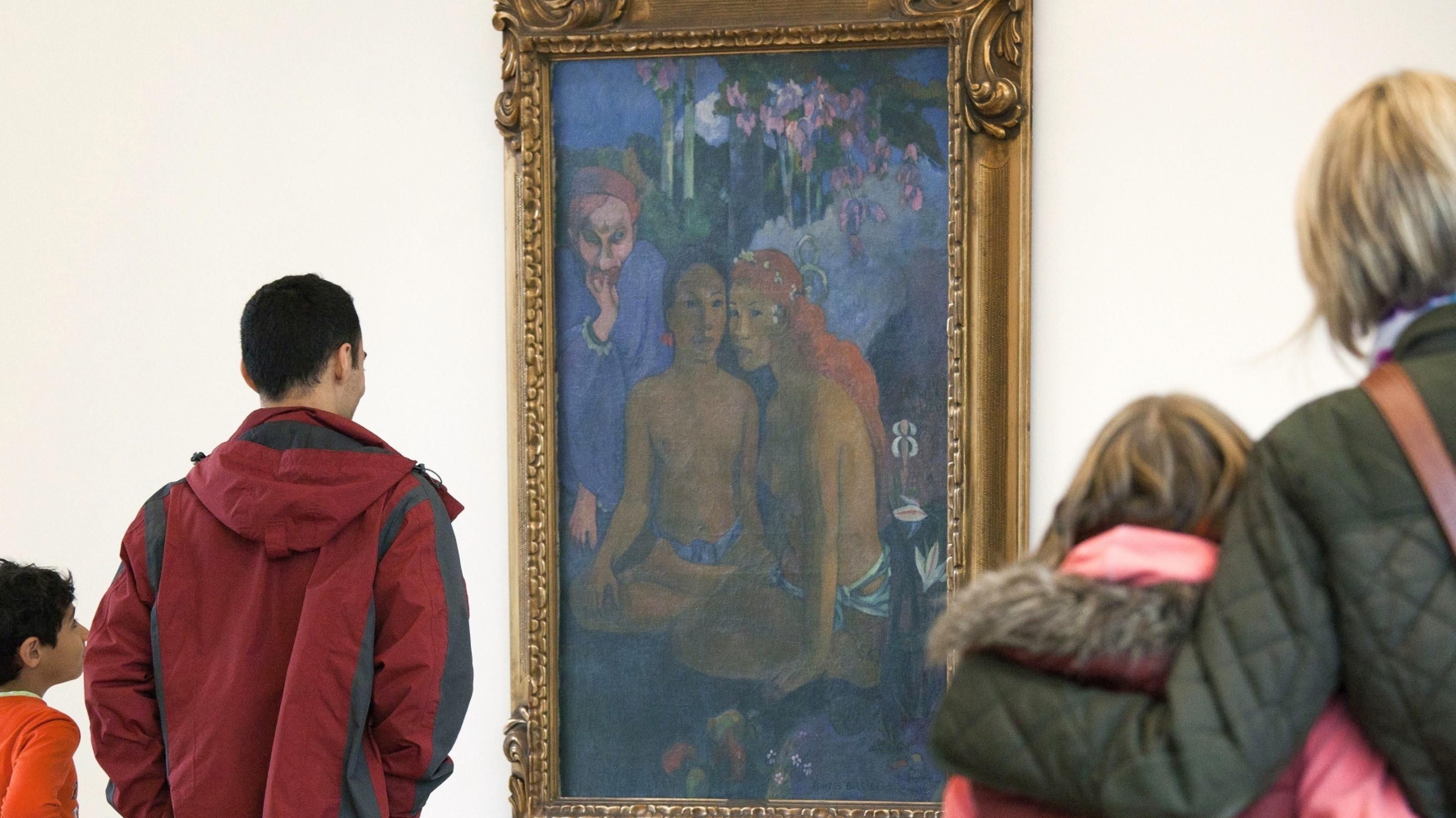 Das Foto zeigt Menschen, die ein Gemälde betrachten.