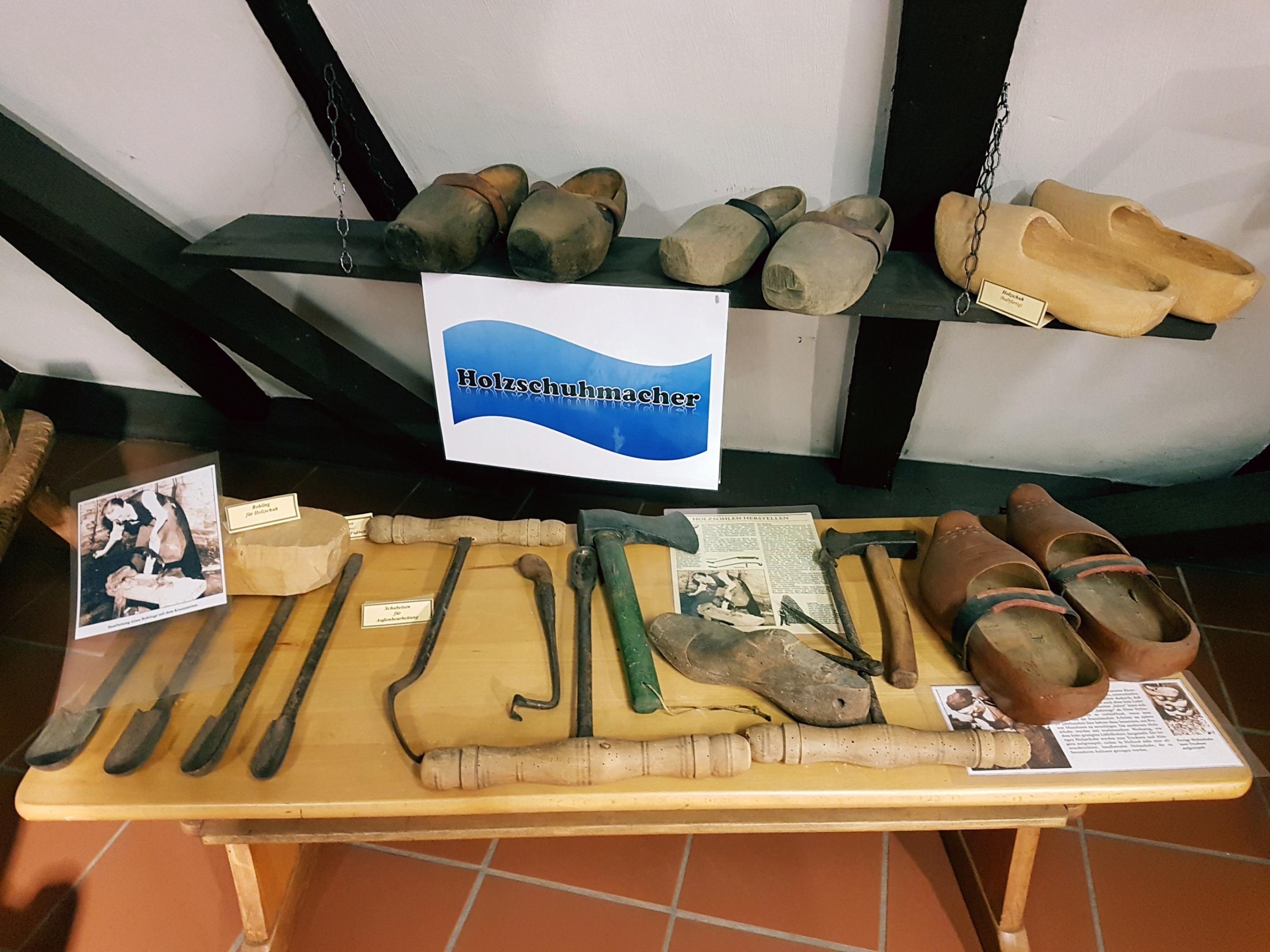 Werkzeug und Holzschuhe auf einem Tisch