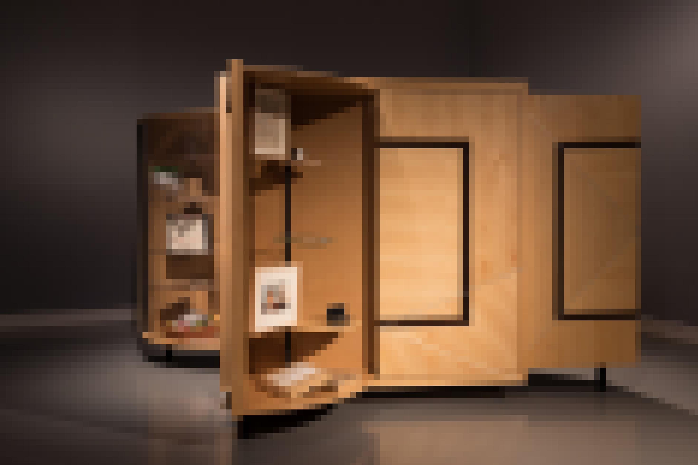 Das Foto zeigt einen ungewöhnlichen Schrank aus Holz. Er steht mitten im Raum, einige Türen des allseitig mit Fächern ausgestatteten Schranks sind geöffnet.