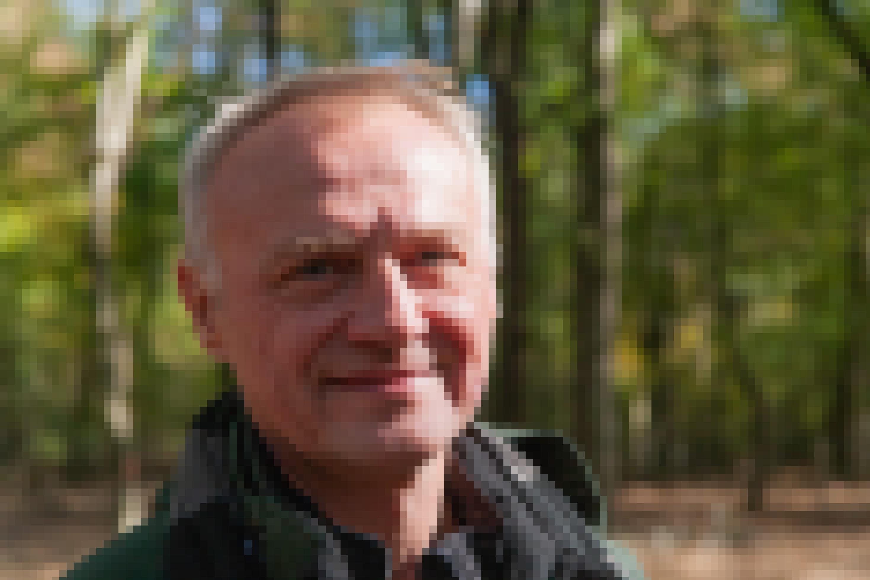 Portrait von Dr. Andreas Skibbe im Wald. Er lächelt in die Kamera.