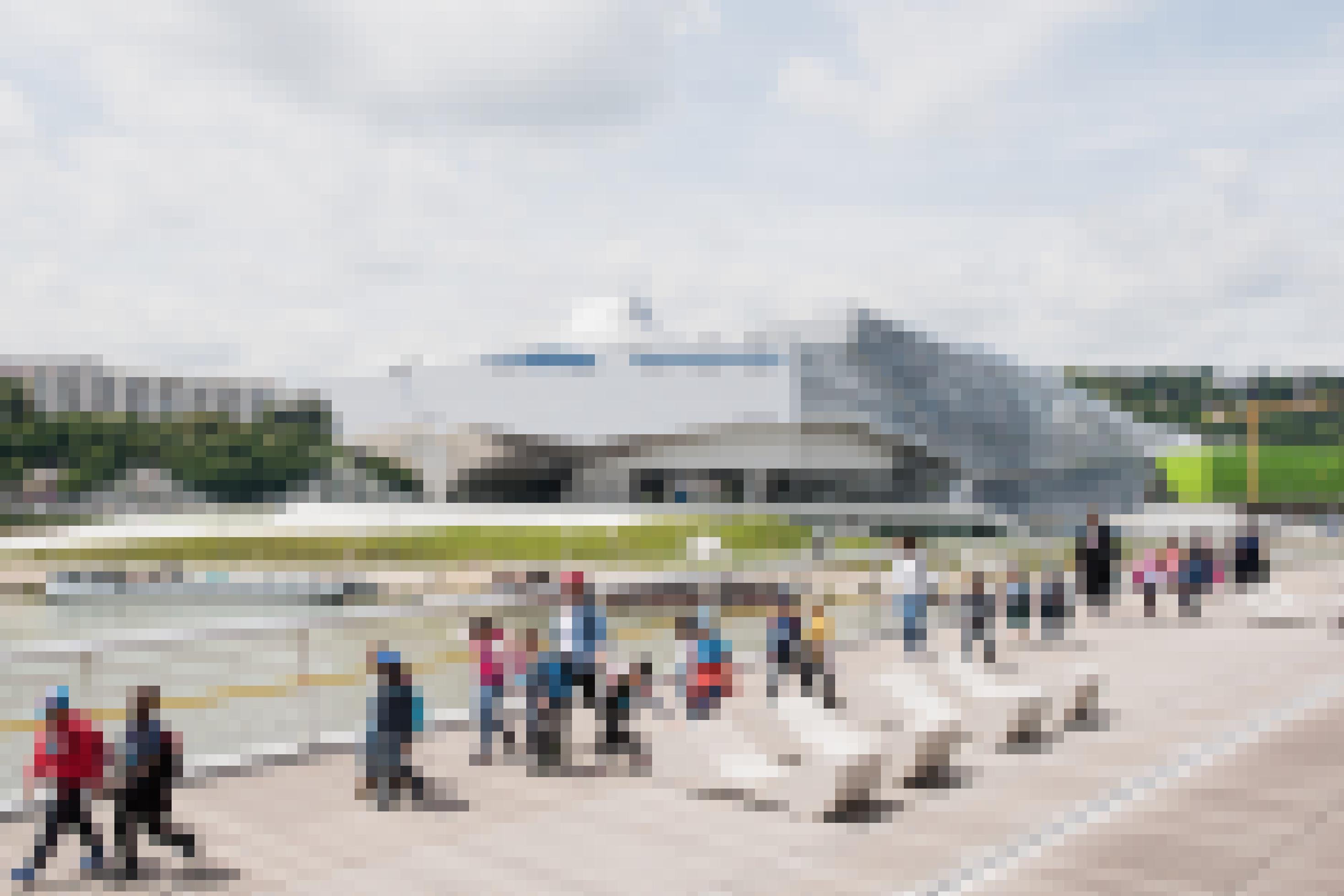 Eine Brücke über einem Fluss. Im Hintergrund ein moderner Museumsbau.