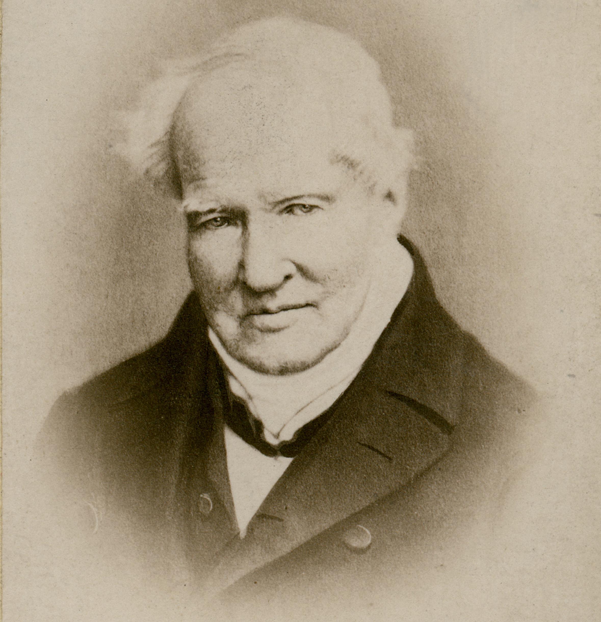 Der Forscher Alexander von Humboldt als alter Mann mit weißem Haar in dunklem Mantel mit weißem Halstuch auf einem Schwarzweißbild.
