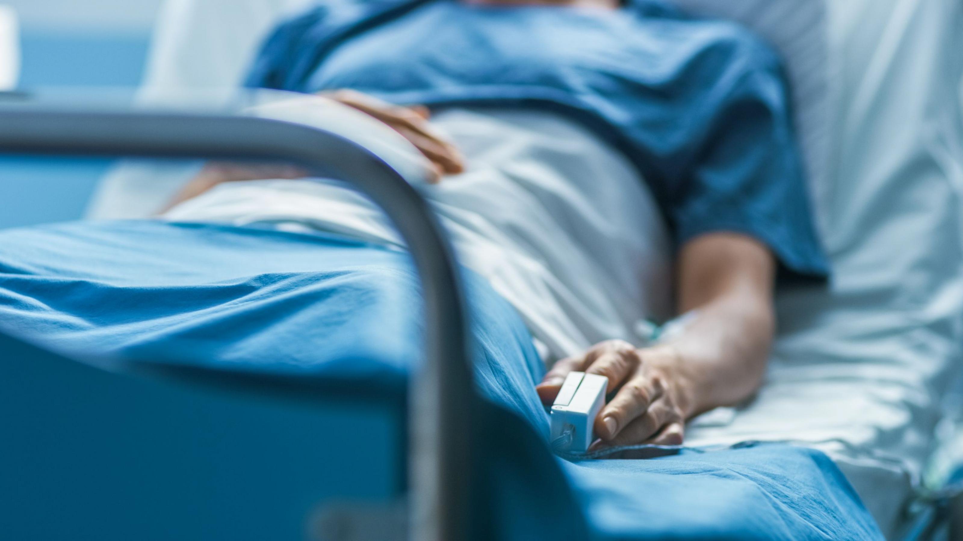 Ein Patient liegt im Krankenhaus im Bett. Mit einer Patientenverfügung kann er festlegen, wie die weitere Behandlung bei schwerer Krankheit aussehen soll.