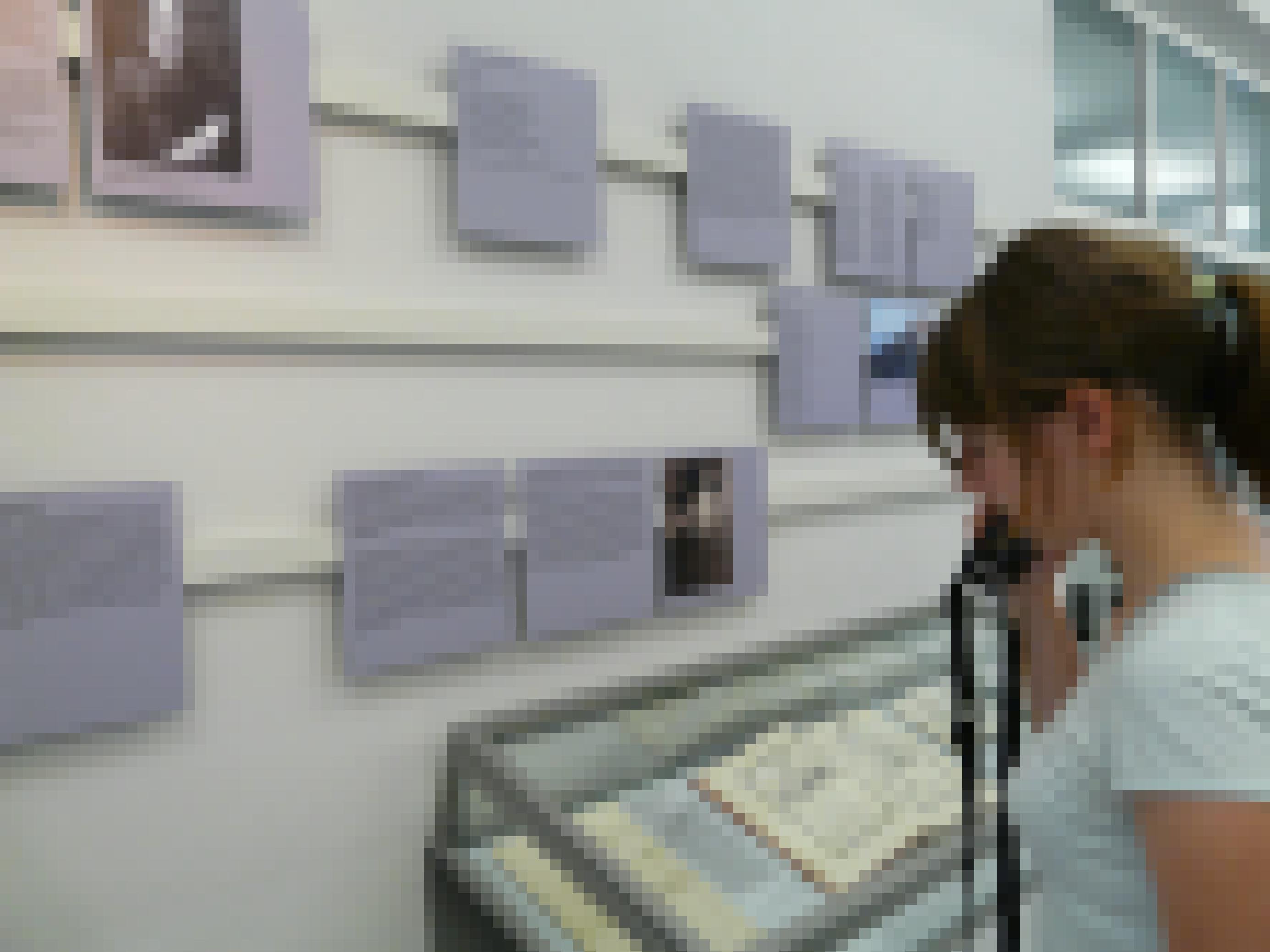Das Foto zeigt eine junge Frau mit Audioguide im Museum für Literatur am Oberrhein vor einer Vitrine, in der Bücher und Schriftstücke liegen.