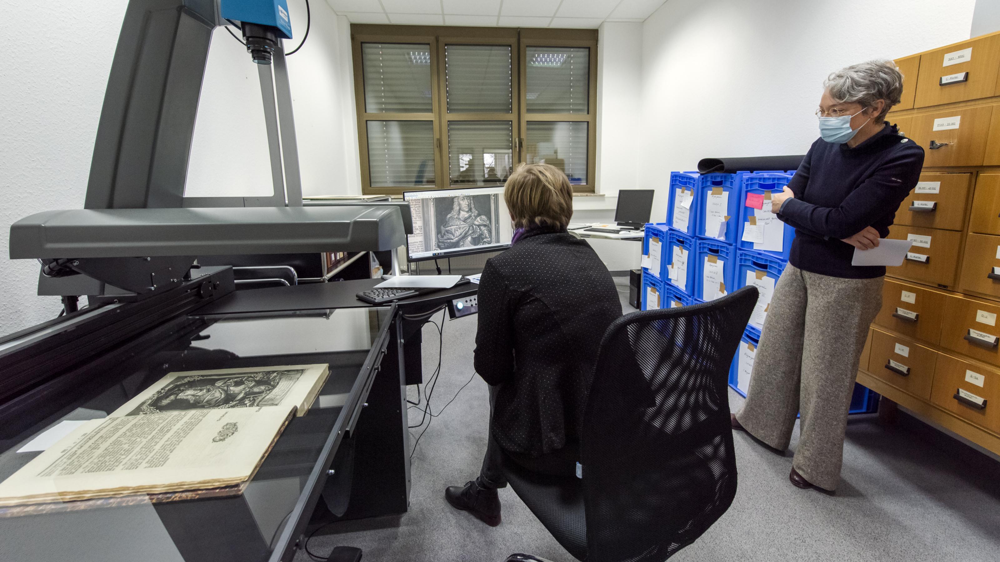 Die Kuratorin des Historischen Museums Frankfurt Dorothee Linnemann demonstriert der Kulturdezernentin Ina Hartwig die Funktion des Hochleistungsscanners Suprascan QUARTZ A1.